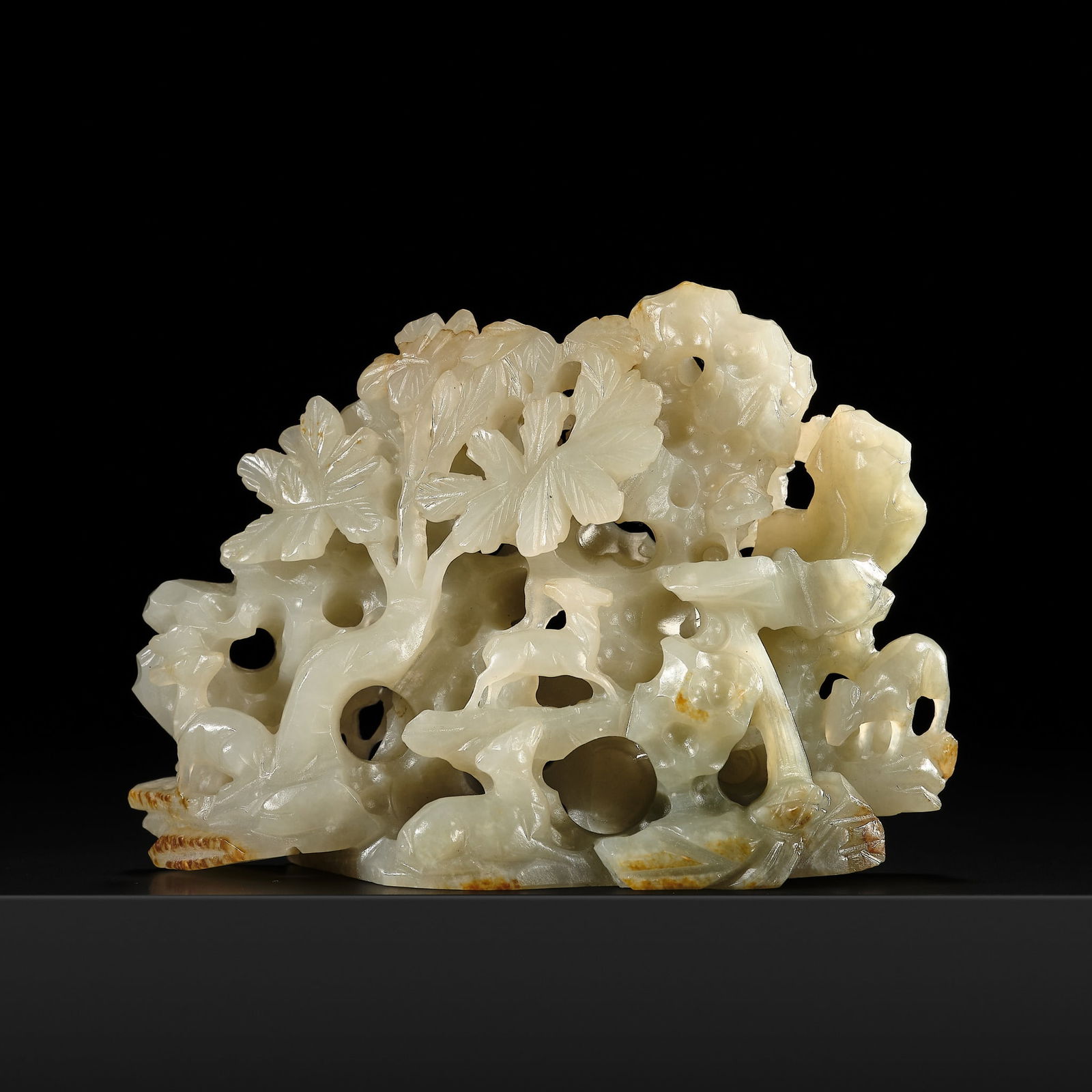 A RETICULATED CELADON AND RUSSET JADE 'ROCK, DEER, AND LINGZHI' GROUP, SONG-YUAN DYNASTY (1 of 16)