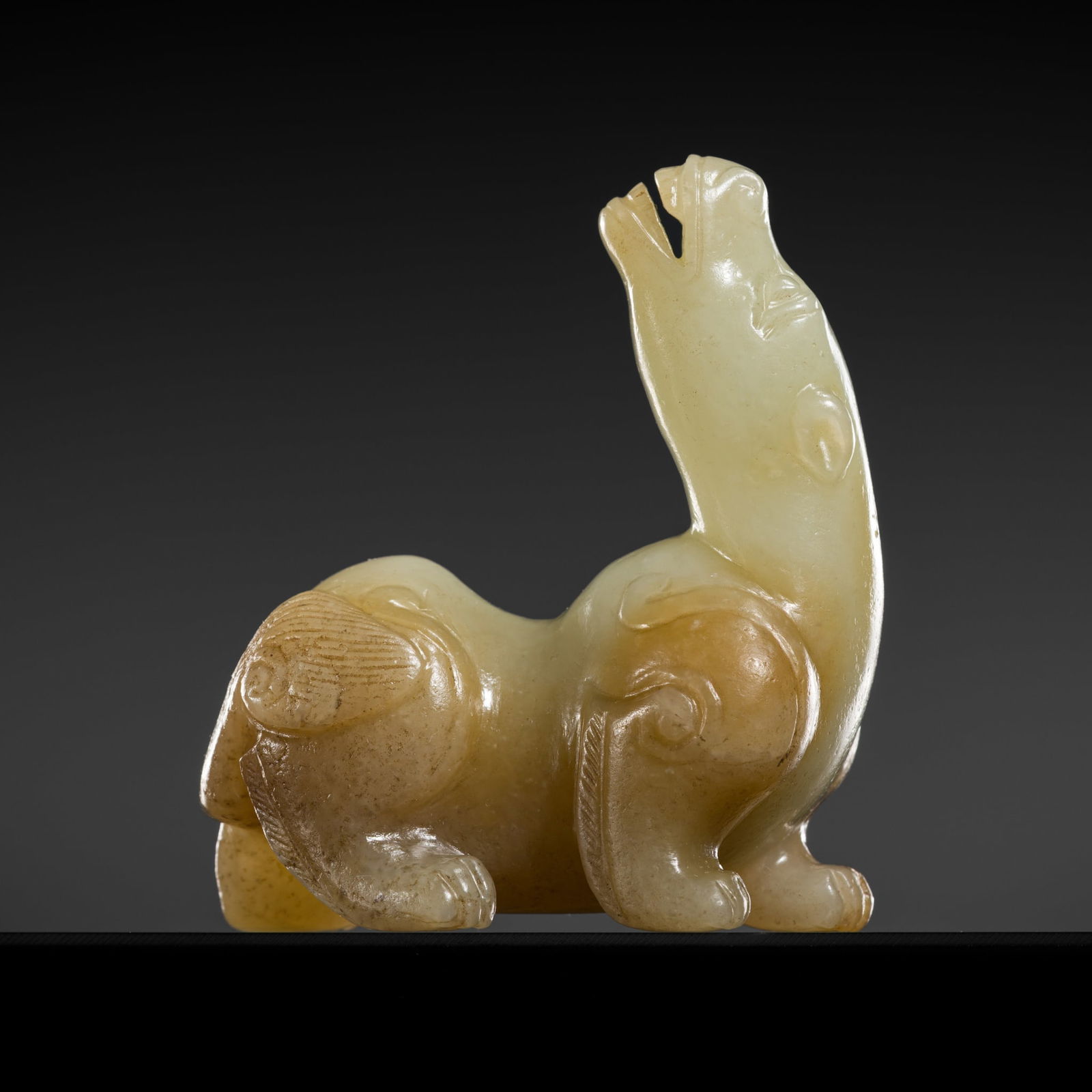 A RUSSET AND CELADON JADE FIGURE OF A MYTHICAL BEAST, MING DYNASTY (1 of 14)