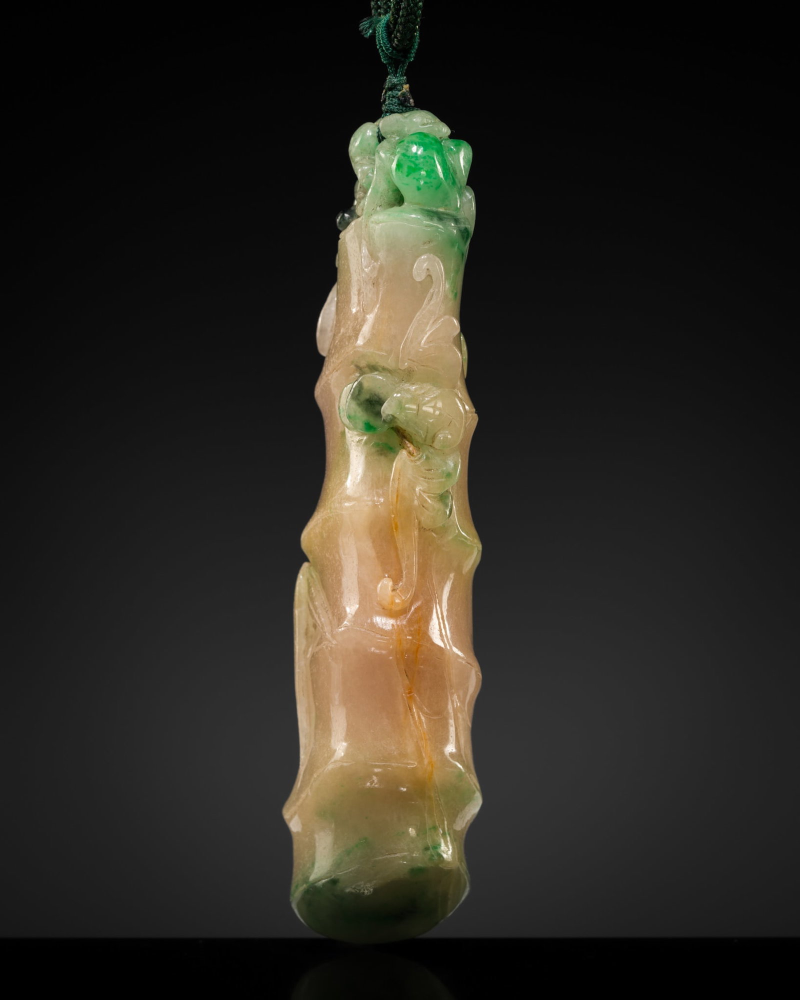 AN APPLE-GREEN JADEITE 'BAMBOO SHOOT' PENDANT, LATE QING DYNASTY TO EARLY REPUBLIC PERIOD: AN APPLE-GREEN JADEITE 'BAMBOO SHOOT' PENDANT, LATE QING DYNASTY TO EARLY REPUBLIC PERIOD China, late 19th to early 20th century. The large pendant is carved in the form of a ridged bamboo shoot issui