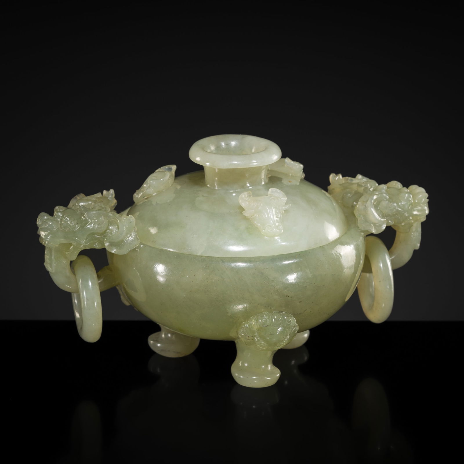 A PALE CELADON JADE TRIPOD CENSER AND COVER, LATE 19TH TO EARLY 20TH CENTURY: A PALE CELADON JADE TRIPOD CENSER AND COVER, LATE 19TH TO EARLY 20TH CENTURY China. Finely carved, the thin walls of compressed globular form, supported on three beast-mask feet, and set with dragon h