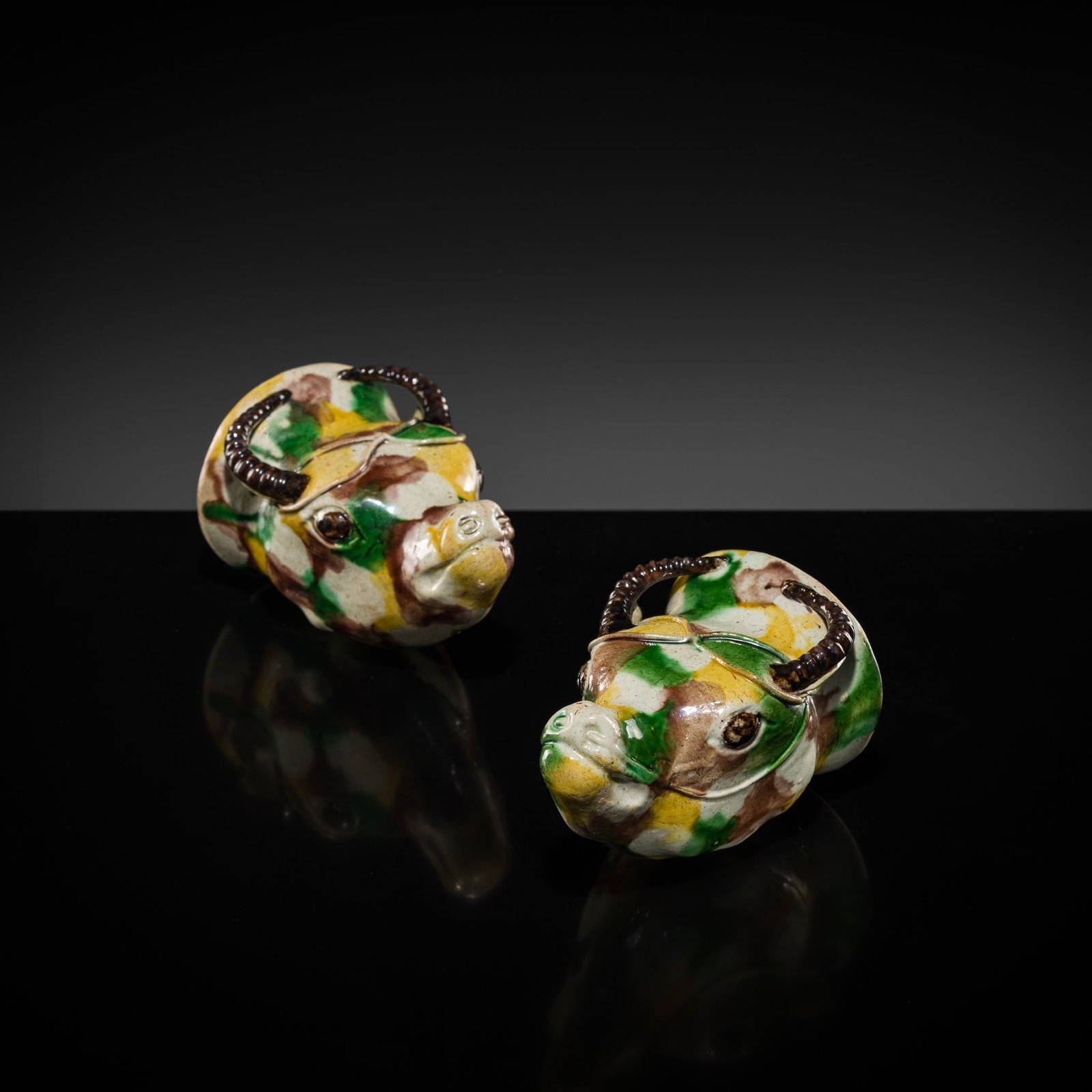 A RARE PAIR OF SANCAI GLAZED BISCUIT 'OX HEAD' LIBATION CUPS, EARLY KANGXI PERIOD: A RARE PAIR OF SANCAI GLAZED BISCUIT 'OX HEAD' LIBATION CUPS, EARLY KANGXI PERIOD Published & Exhibited: Marchant, London, 2025, website, stock number M5580/1, priced at GBP 6,250 or approx. EUR 7