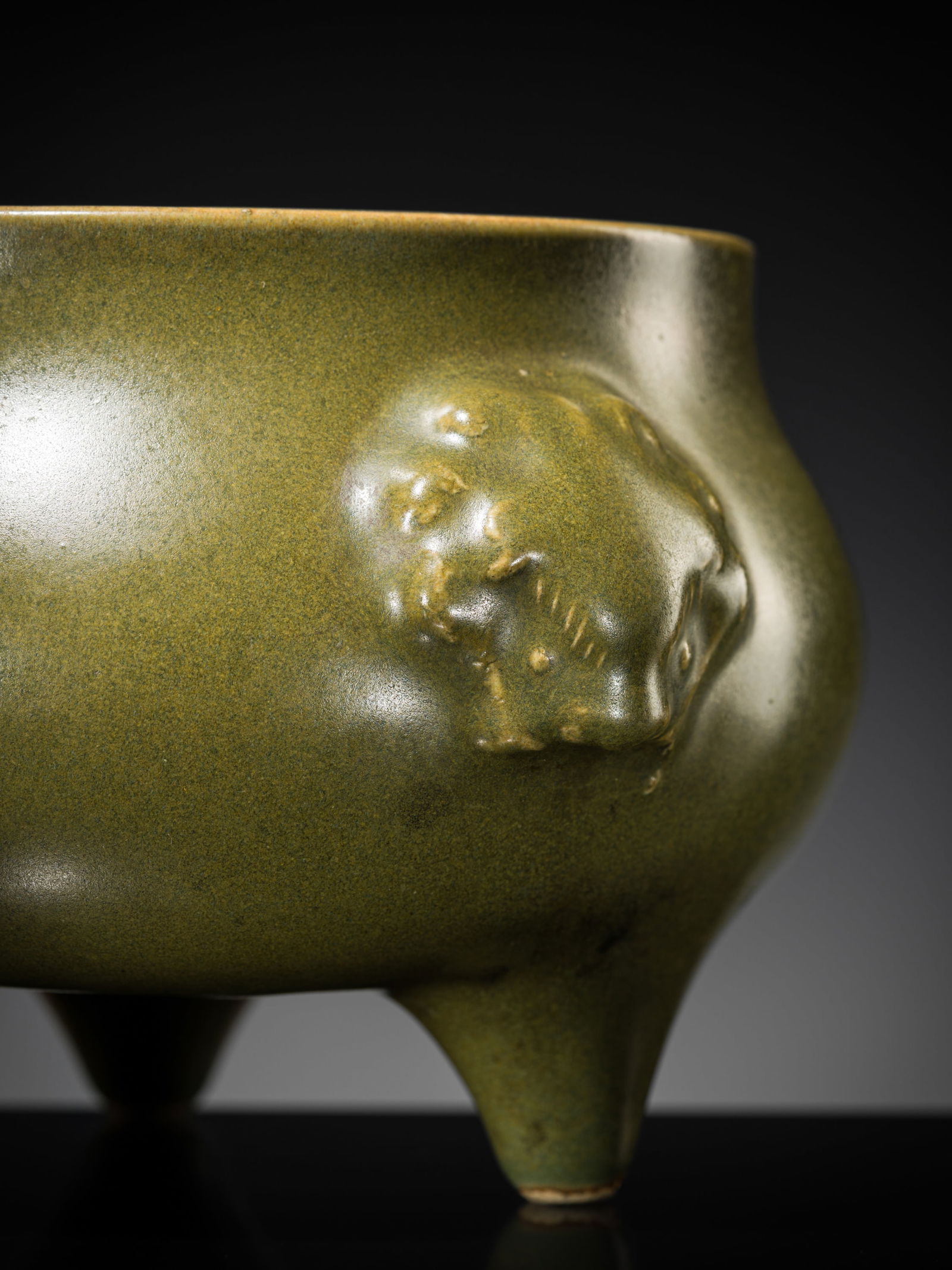 A TEADUST-GLAZED TRIPOD CENSER, 19TH CENTURY: A TEADUST-GLAZED TRIPOD CENSER, 19TH CENTURY China. Finely potted with a compressed bombé body supported on three short feet, flanked by a pair of lion mask handles below the flat rim, covered ov