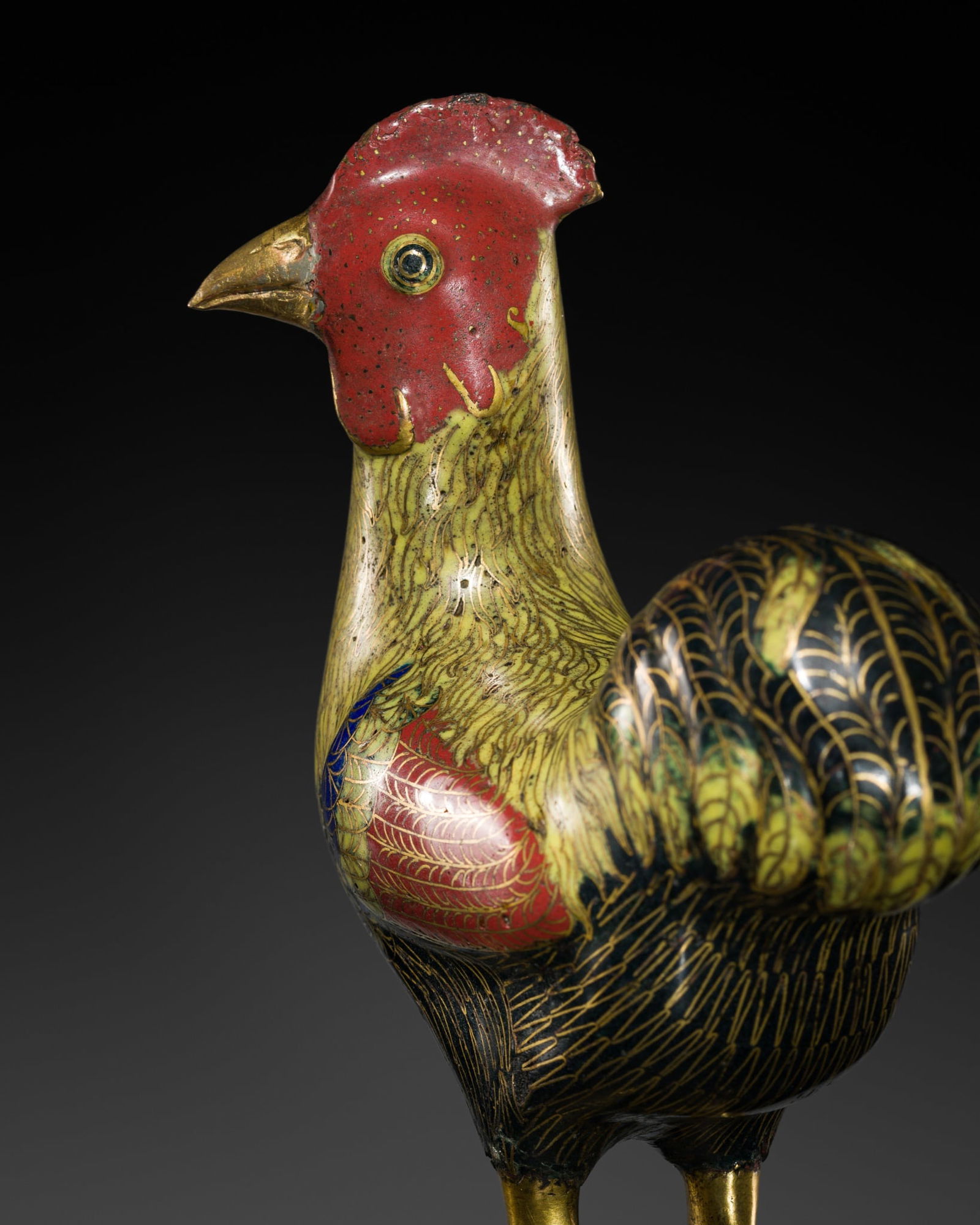 A GILT-COPPER AND CLOISONNE ENAMEL FIGURE OF A ROOSTER, QIANLONG PERIOD: A GILT-COPPER AND CLOISONNE ENAMEL FIGURE OF A ROOSTER, QIANLONG PERIOD China, 1736-1795. Finely modeled standing, with folded wings and the head turned to one side, the plumage delicately enameled in