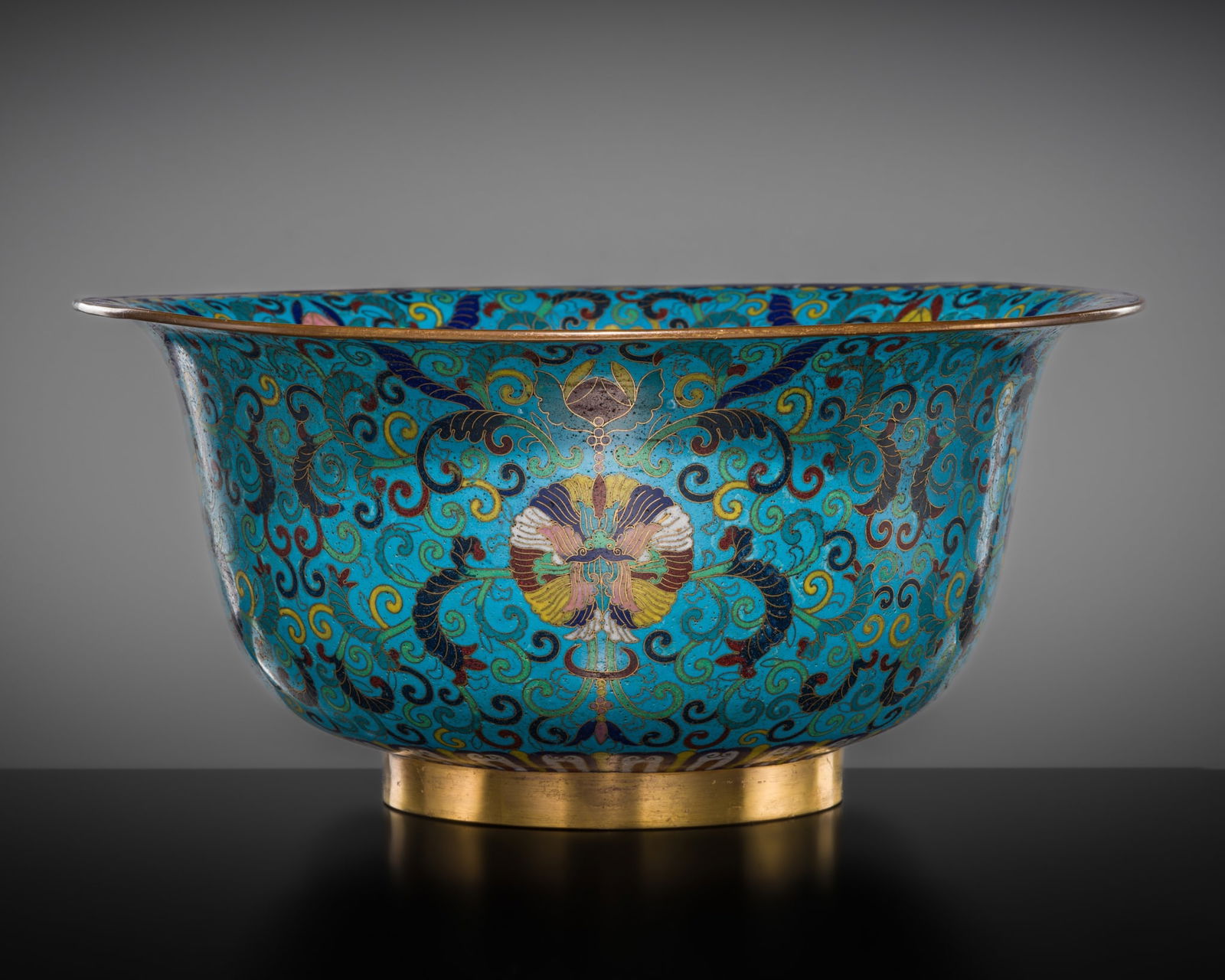 A LARGE CLOISONNÉ ENAMEL 'LOTUS' BOWL, LATE 18TH CENTURY TO EARLY 19TH CENTURY: A LARGE CLOISONNÉ ENAMEL 'LOTUS' BOWL, LATE 18TH CENTURY TO EARLY 19TH CENTURY China. The deep bowl is formed with rounded sides rising to an everted mouth rim, decorated along the upper edge wit