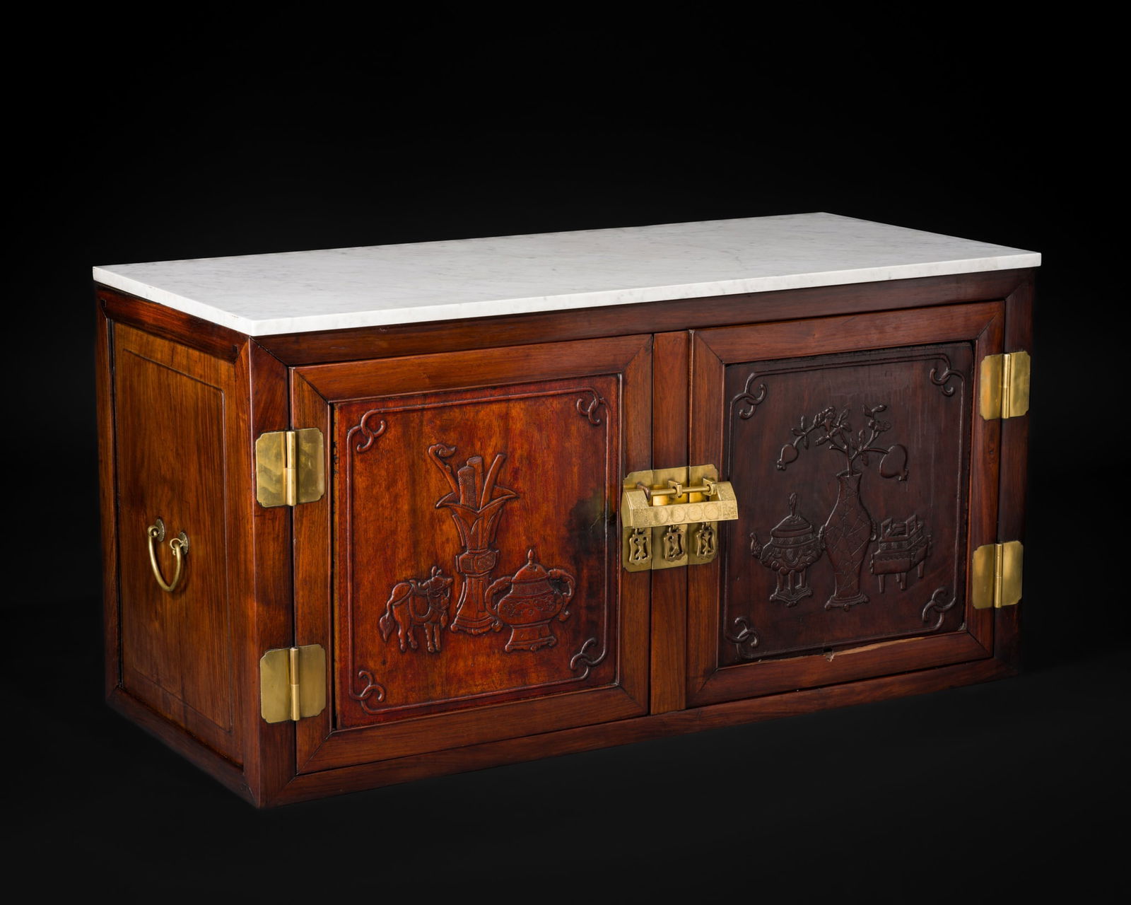 A HUANGHUALI 'HUNDRED ANTIQUES' SIDE CABINET, CHINA, 19TH CENTURY: A HUANGHUALI 'HUNDRED ANTIQUES' SIDE CABINET, CHINA, 19TH CENTURY Of rectangular form, the front is fitted with a pair of paneled doors mounted with brass hinges and centered by matching brass hasps a