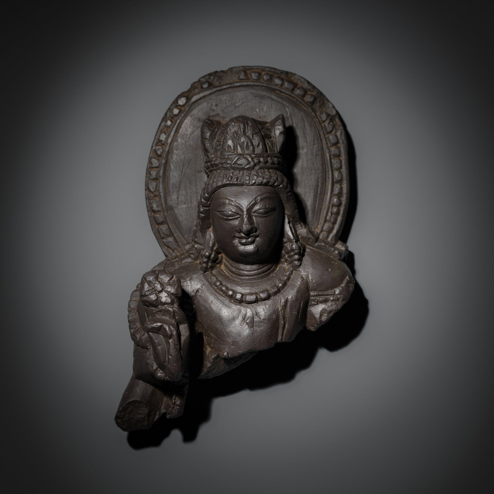A GRAY SCHIST BUST OF VISHNU, KASHMIR, 8TH-9TH CENTURY: A GRAY SCHIST BUST OF VISHNU, KASHMIR, 8TH-9TH CENTURY A superb example of its type, expressively carved and harmoniously balancing clarity of form with refined detail. The deity holds a lotus in his