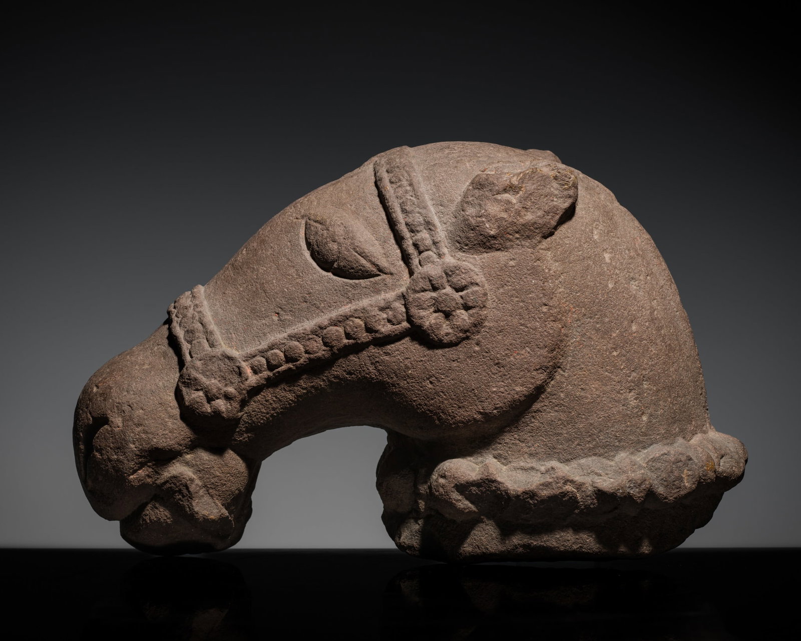 A SANDSTONE HEAD OF A HORSE, KHAJURAHO, CHANDELA PERIOD, 10TH-11TH CENTURY: A SANDSTONE HEAD OF A HORSE, KHAJURAHO, CHANDELA PERIOD, 10TH-11TH CENTURY Central India, Madhya Pradesh. Finely carved, the head with a beaded bridle secured with foliate medallions, wide almond-shap