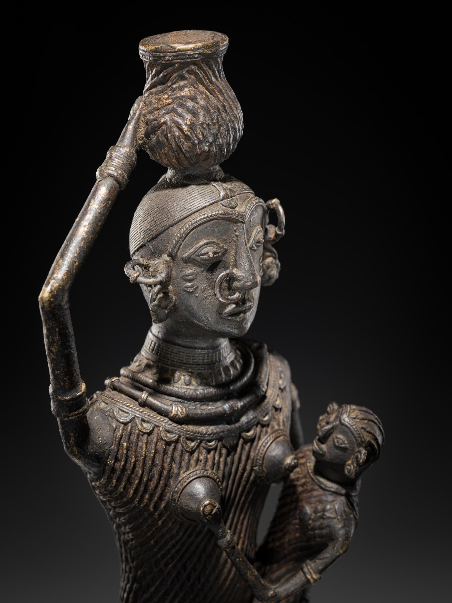 A KONDH TRIBAL BRONZE FIGURE OF A DANGARIAN MOTHER AND INFANT, ORISSA, 19TH CENTURY: A KONDH TRIBAL BRONZE FIGURE OF A DANGARIAN MOTHER AND INFANT, ORISSA, 19TH CENTURY Eastern India. Expressively cast, the figure stands poised while balancing a water pot upon her head. She is clad in