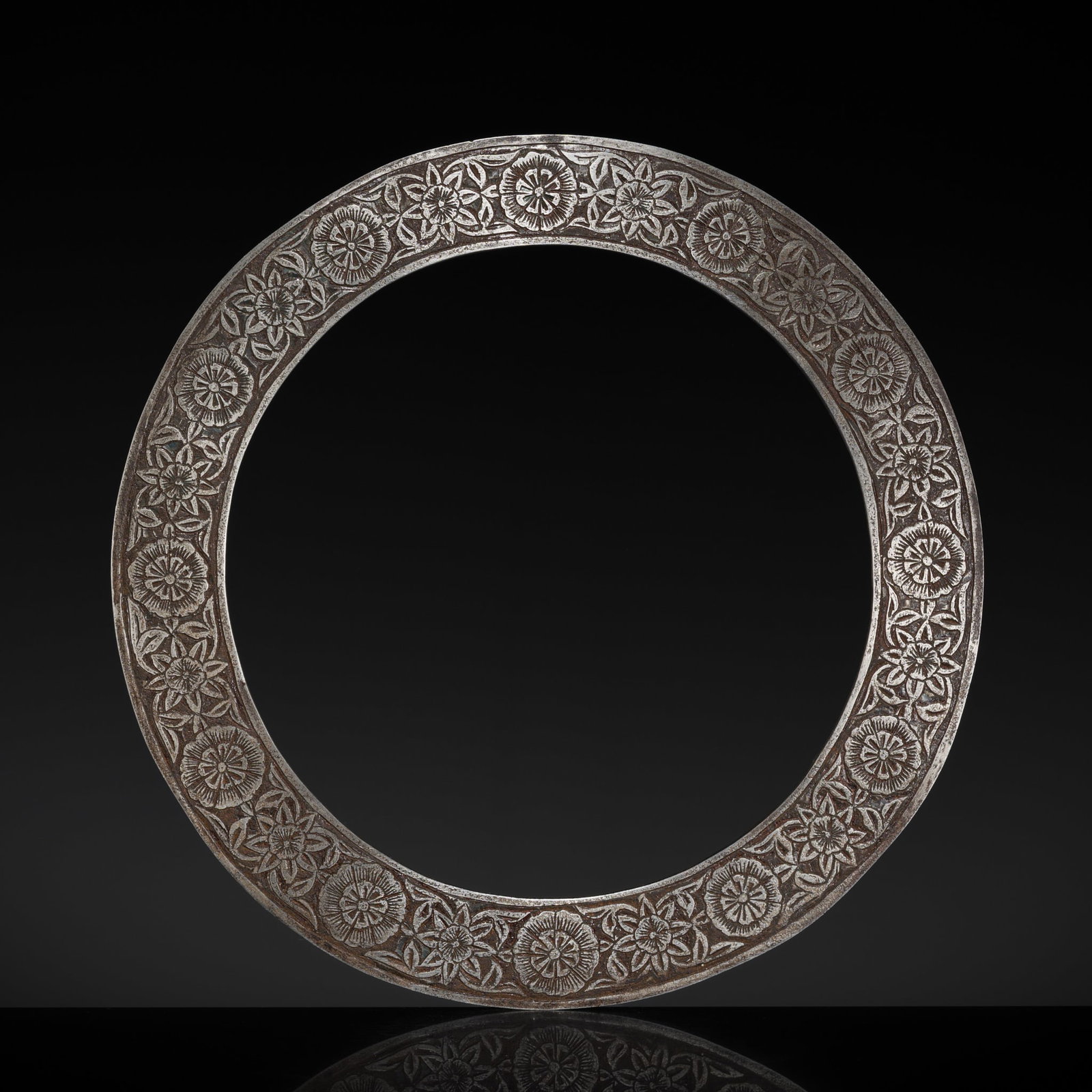 A SIKH STEEL QUOIT, CHAKRAM, NORTHERN INDIA, 19TH CENTURY: A SIKH STEEL QUOIT, CHAKRAM, NORTHERN INDIA, 19TH CENTURY The disc made of flat steel finely incised to both sides with a floral band of alternating blossoms framed within raised borders. The outer ed