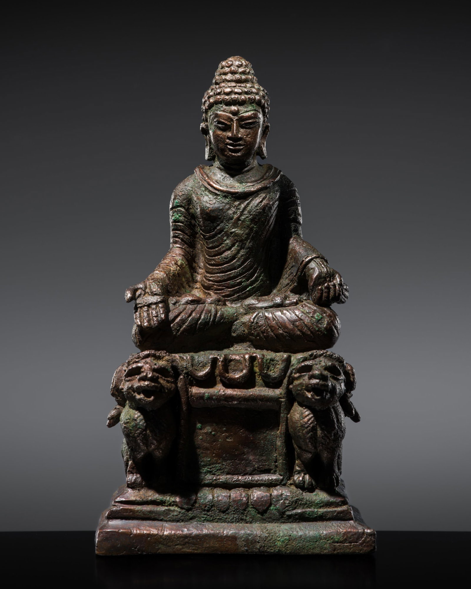 A SILVER-INLAID BRONZE FIGURE OF BUDDHA ON A LION THRONE, SWAT VALLEY, 8TH-9TH CENTURY: A SILVER-INLAID BRONZE FIGURE OF BUDDHA ON A LION THRONE, SWAT VALLEY, 8TH-9TH CENTURY Seated in dhyanasana atop an elaborate pedestal supported by lions, raised on a lotus base atop a waisted plinth,