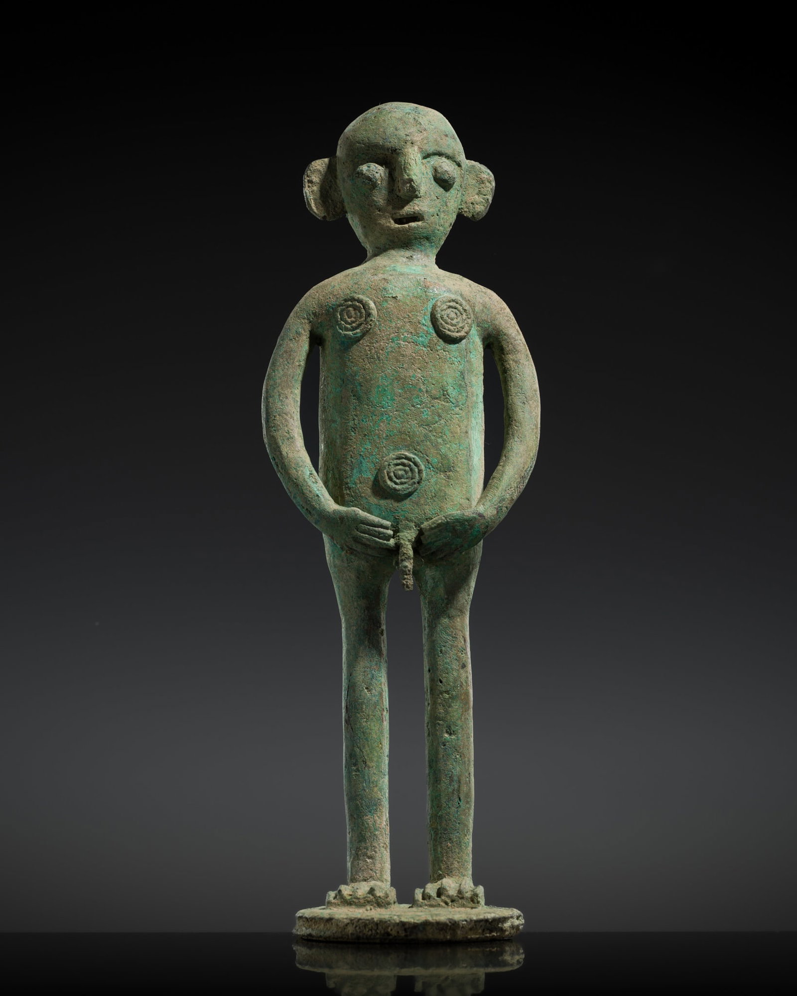 A RARE BRONZE FIGURE OF A MAN, DONG SON CULTURE: A RARE BRONZE FIGURE OF A MAN, DONG SON CULTURE Vietnam, 500 BC-300 AD. Finely cast, the man standing on a circular base and gazing up at the sky, with his hands lowered toward his waist, framing his