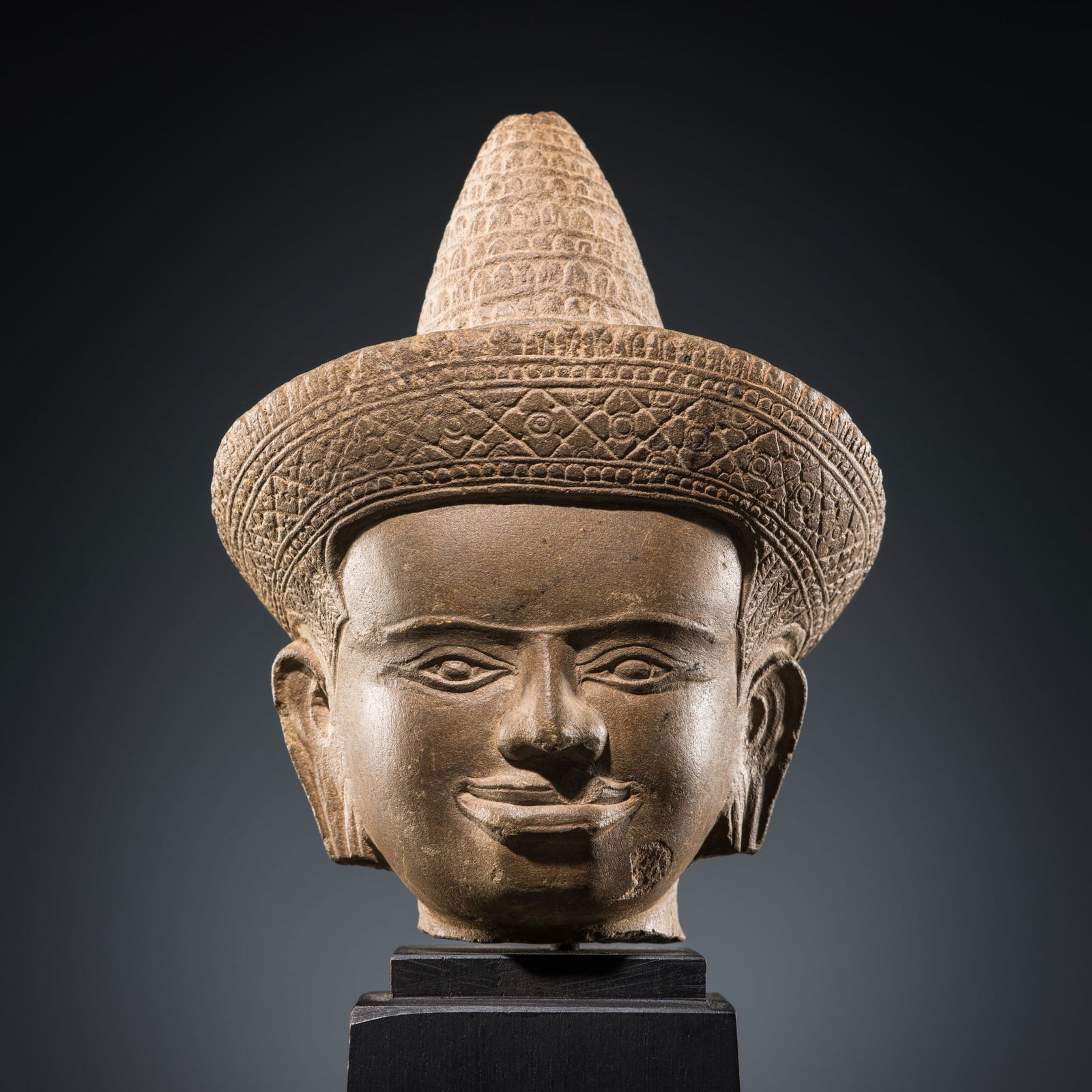 A SANDSTONE HEAD OF A MALE DEITY, ANGKOR PERIOD, BAPHUON STYLE (1 of 14)