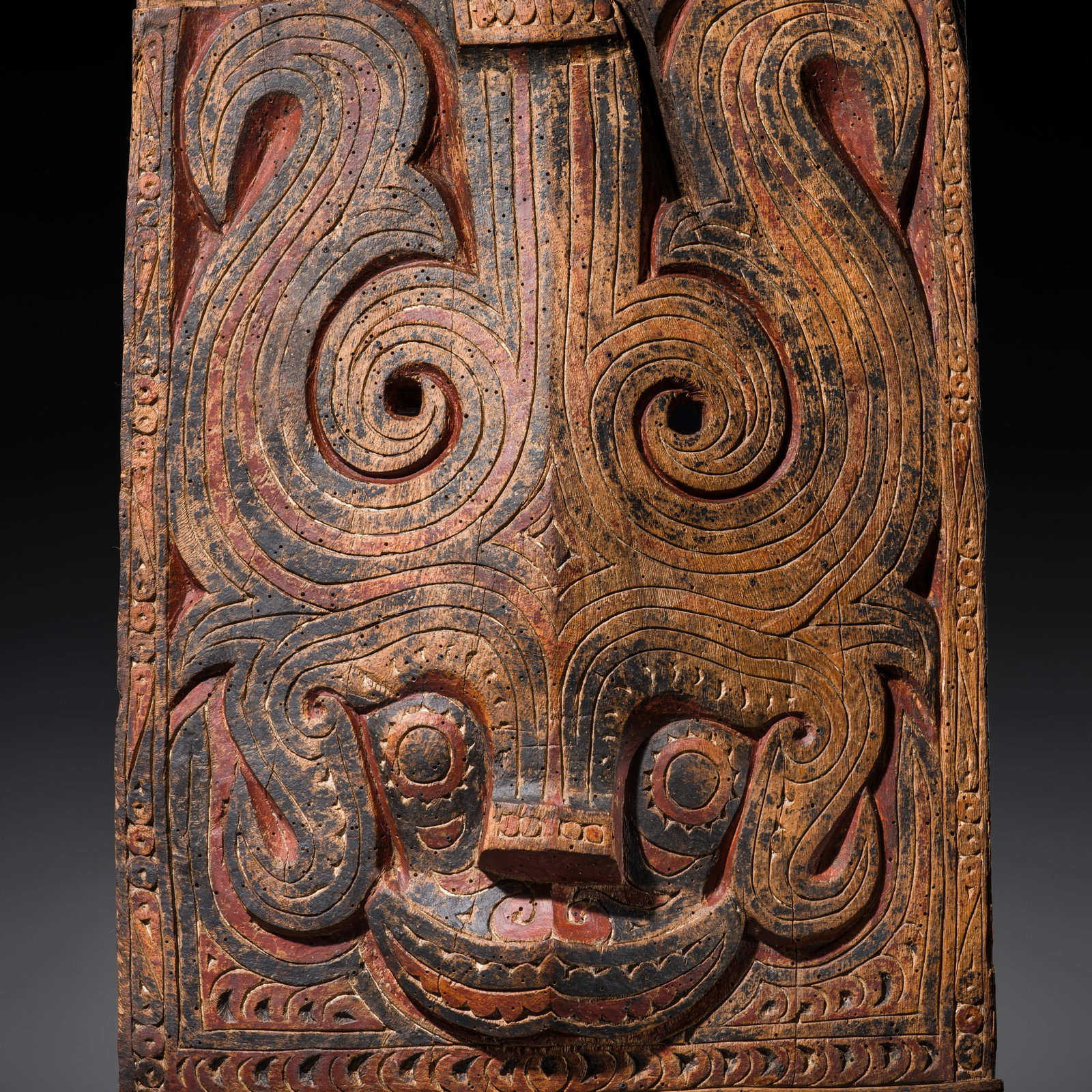 A POLYCHROME CARVED WOOD 'SINGA' ARCHITECTURAL ORNAMENT, TOBA BATAK PEOPLE, 19TH-EARLY 20TH CENTURY: A POLYCHROME CARVED WOOD 'SINGA' ARCHITECTURAL ORNAMENT, TOBA BATAK PEOPLE, 19TH-EARLY 20TH CENTURY Indonesia, North Sumatra. Of rectangular form, boldly carved in high relief and richly polychromed t