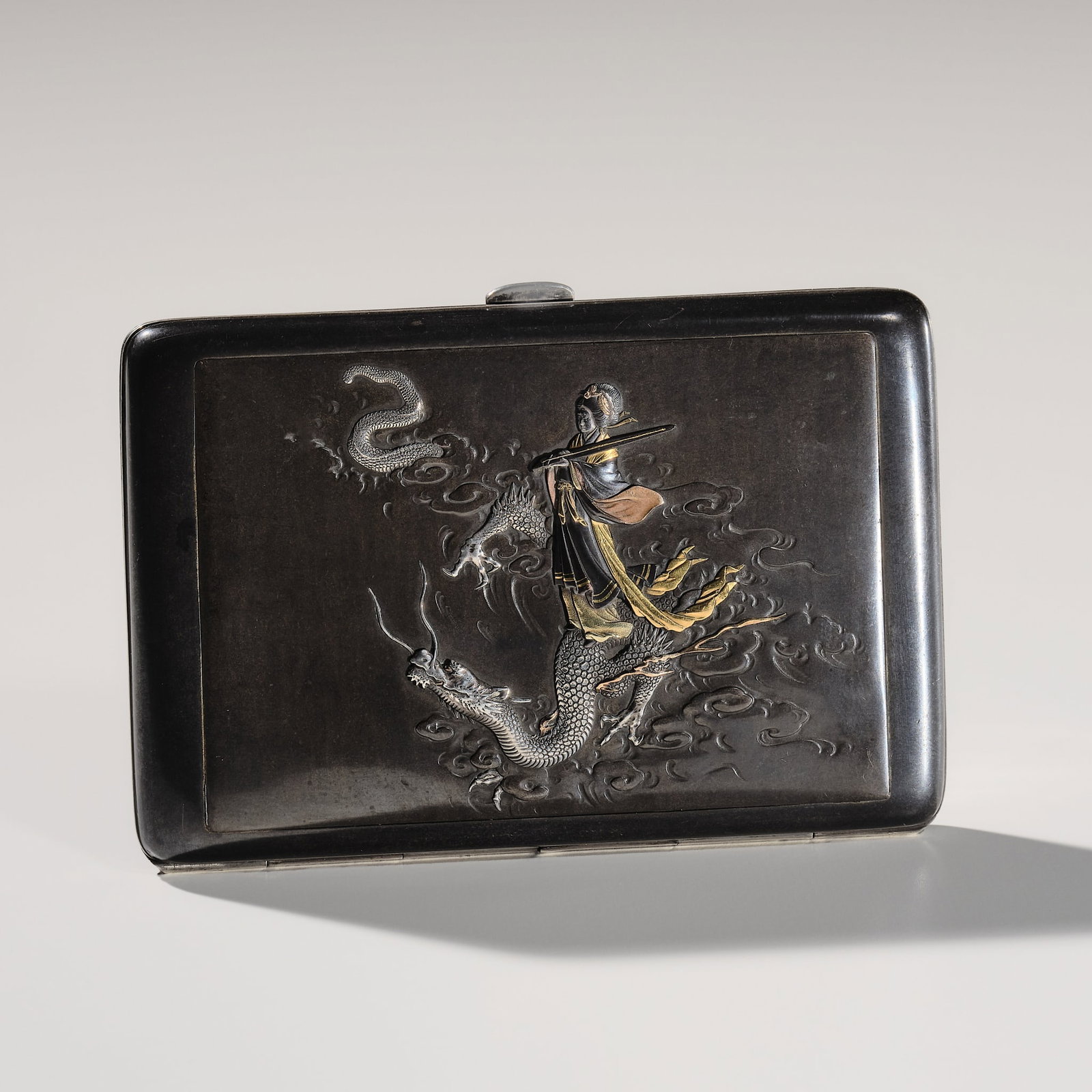 KORYU FOR THE KOMAI COMPANY: A FINE GOLD-INLAID SHIBUICHI 'BENTEN' CIGARETTE CASE: KORYU FOR THE KOMAI COMPANY: A FINE GOLD-INLAID SHIBUICHI 'BENTEN' CIGARETTE CASE By Koryu for the Komai Company, signed Koryu koku no with seal Ko and sealed Nihon koku Kyoto ju Komai sei Japan, Meij