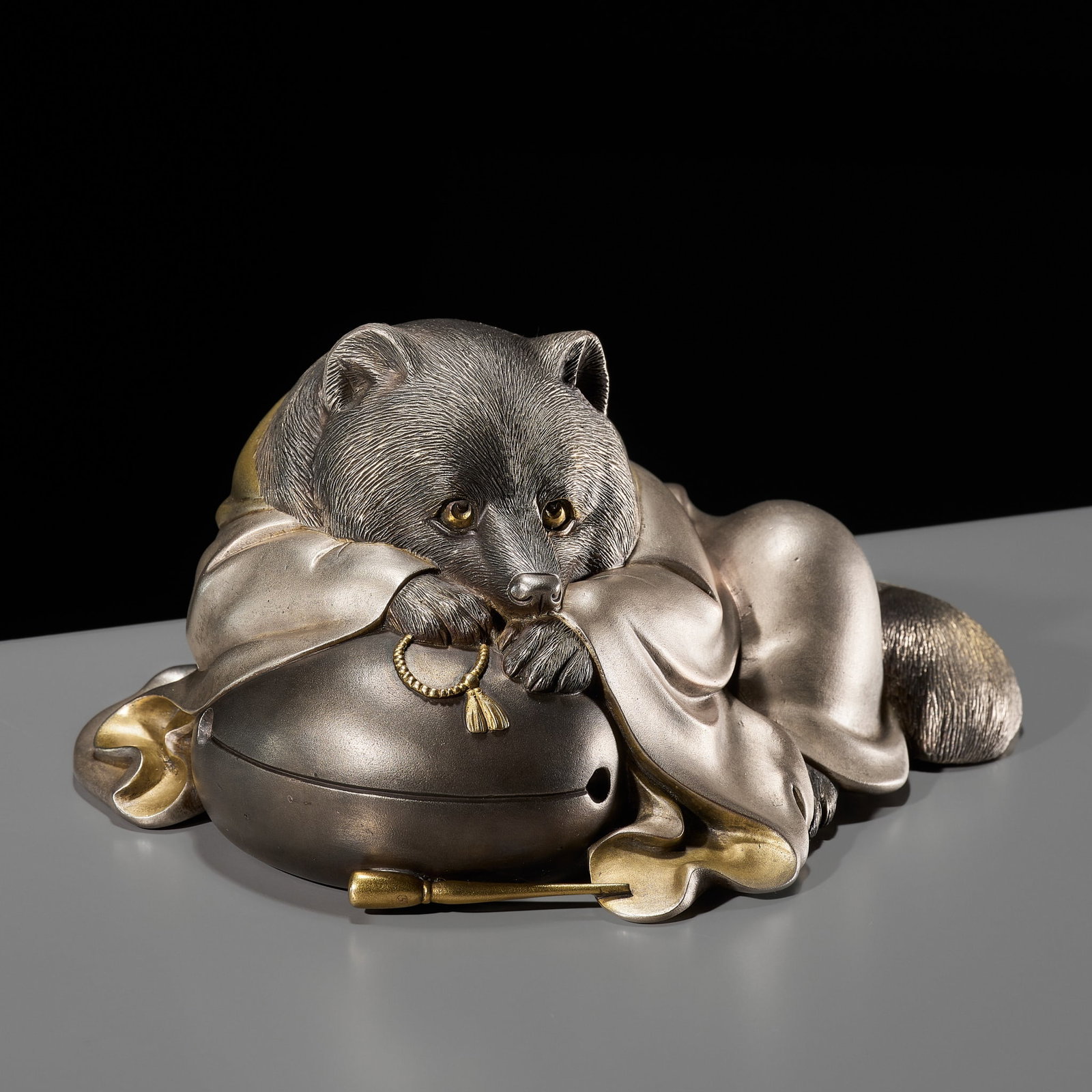 AKASOFU GYOKKO: A FINE SILVERED BRONZE OKIMONO OF TANUKI SHUKAKU: AKASOFU GYOKKO: A FINE SILVERED BRONZE OKIMONO OF TANUKI SHUKAKU By Akasofu Gyoko, signed Dai Nihon Gyokko saku Japan, Meiji period (1868-1912) Cast as a recumbent racoon dog disguised as a Buddhist p