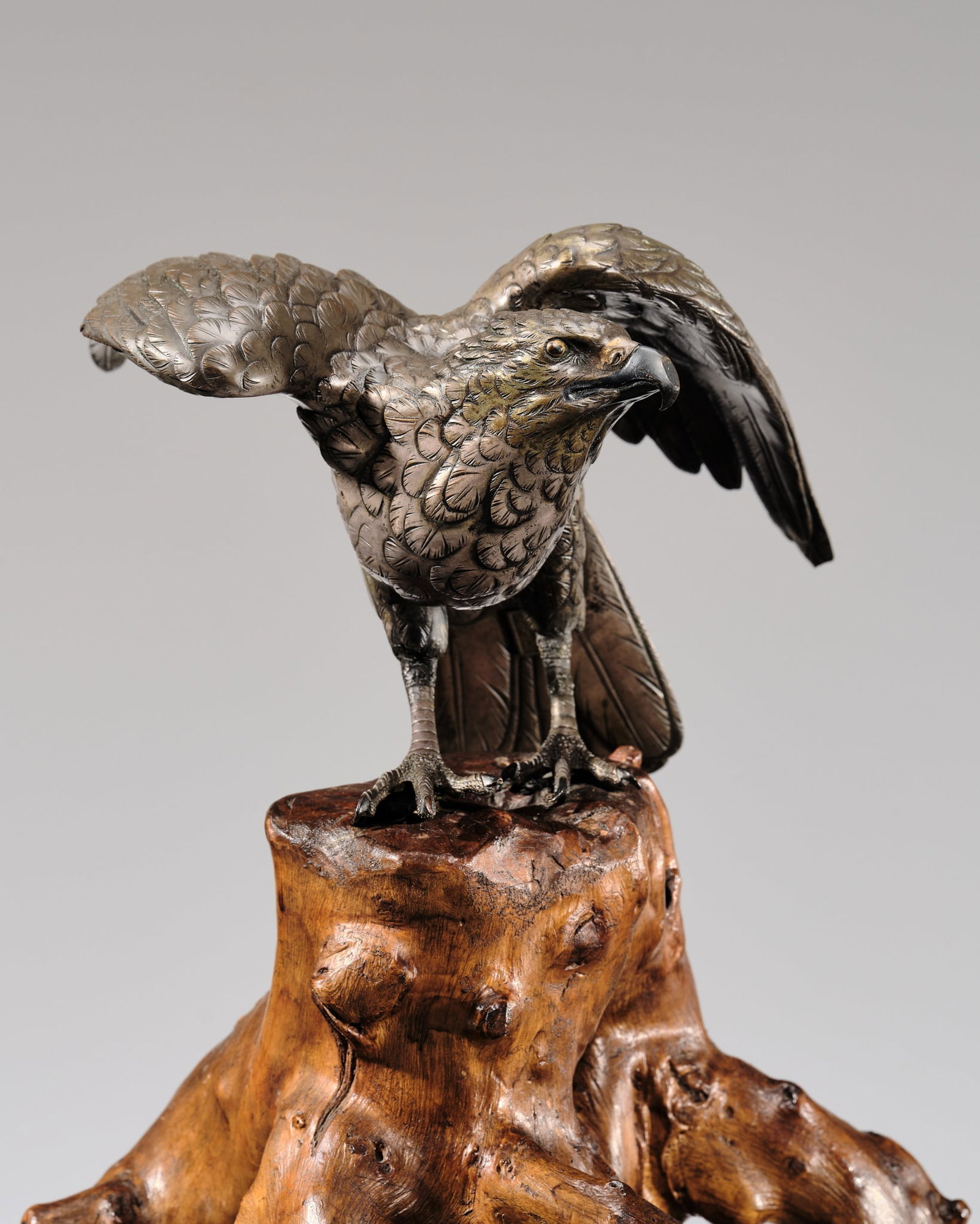 GENRYUSAI SEIYA: A FINE BRONZE AND ROOTWOOD OKIMONO OF A KESTREL ON A TREE STUMP: GENRYUSAI SEIYA: A FINE BRONZE AND ROOTWOOD OKIMONO OF A KESTREL ON A TREE STUMP Japan, Meiji period (1868-1912) Superbly cast, this raptor is perched on a separately carved wood base in the shape of 