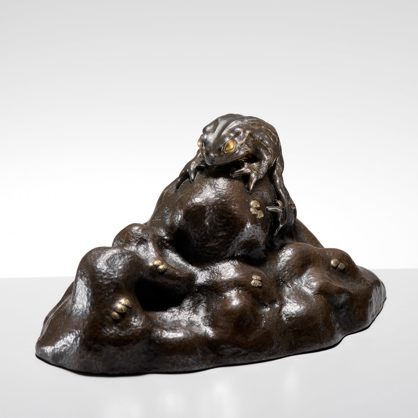 SEKIGUCHI ICHIYA: A BRONZE OKIMONO OF A TOAD ON ROCKS: SEKIGUCHI ICHIYA: A BRONZE OKIMONO OF A TOAD ON ROCKS By Sekiguchi Ichiya (1850-1933), signed Ichiya Japan, early 20th century, Meiji (1868-1912) to Taisho period (1912-1926) Naturalistically cast as