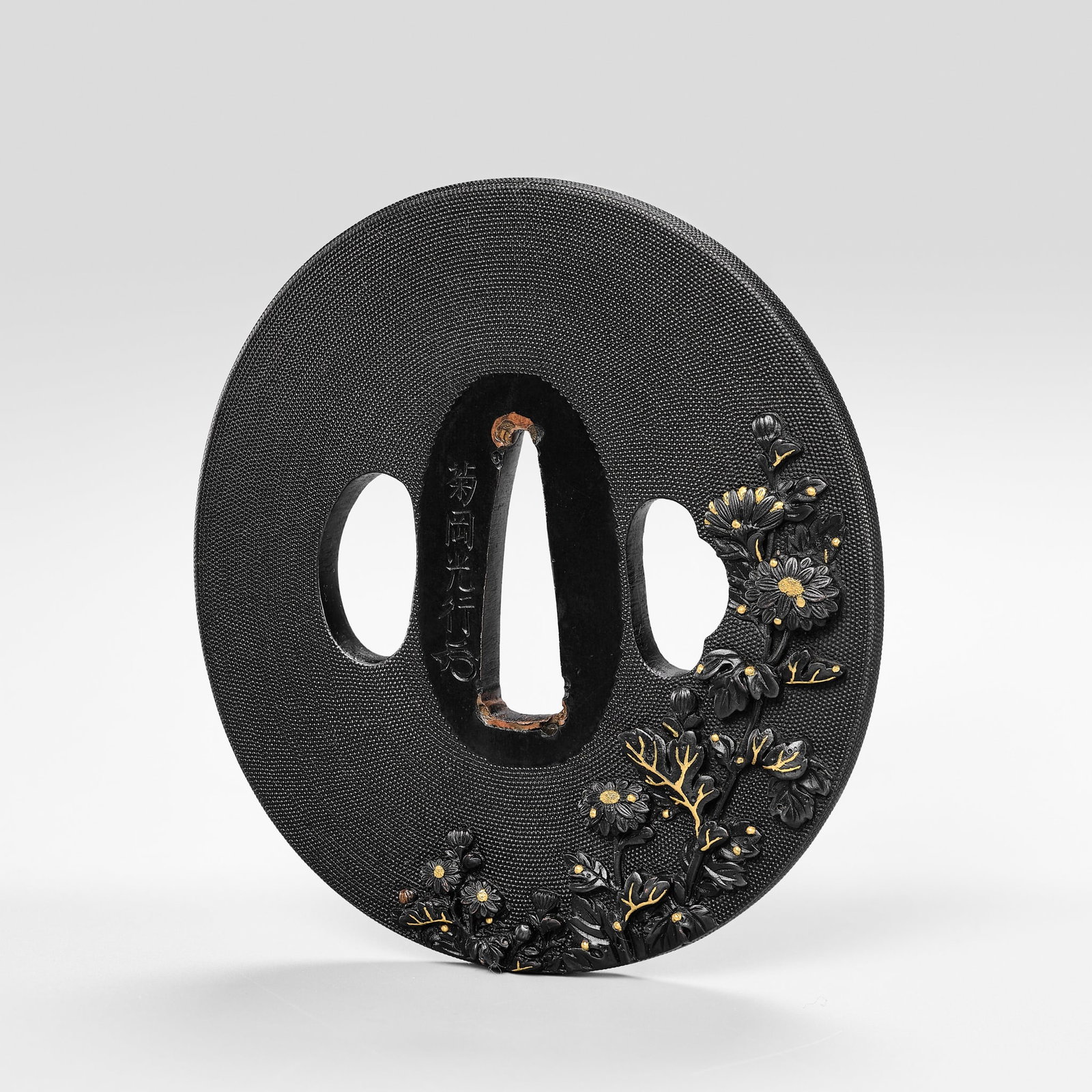 KIKUOKA MITSUYUKI: A FINE SHAKUDO NANAKO 'CHRYSANTHEMUMS' TSUBA: KIKUOKA MITSUYUKI: A FINE SHAKUDO NANAKO 'CHRYSANTHEMUMS' TSUBA By Kikuoka Mitsuyuki (1750-1800) signed Kikuoka Mitsuyuki with kakihan Japan, 18th century, Edo period (1615-1868) Of nagamarugata form,