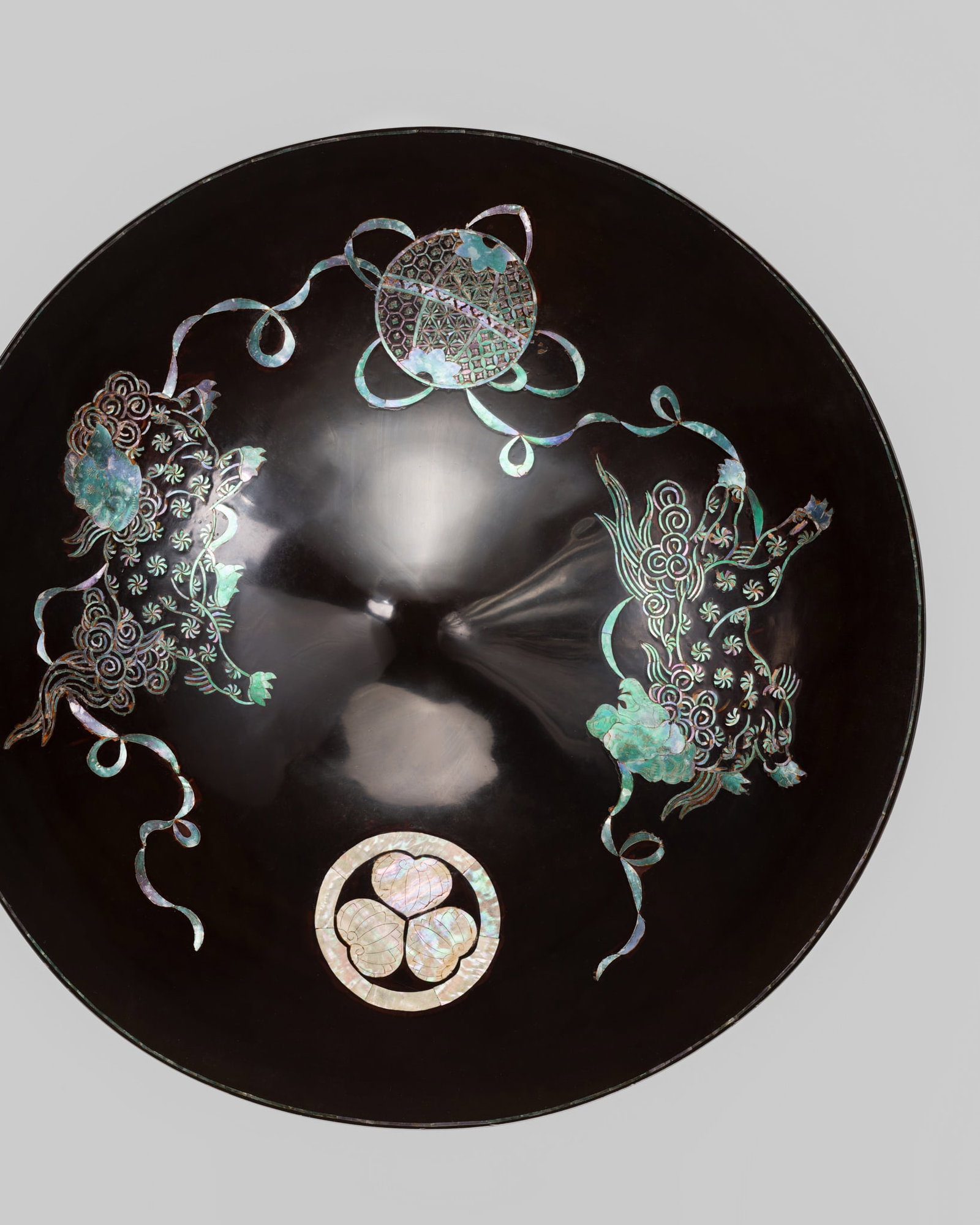 A FINE INLAID AND LACQUERED WOOD JINGASA (WAR HAT) WITH SHISHI AND MITSUBA AOI MON: A FINE INLAID AND LACQUERED WOOD JINGASA (WAR HAT) WITH SHISHI AND MITSUBA AOI MON Japan, 19th century, Edo period (1615-1868) Published: Resonance of Wa - The Japanese Spirit. Casal Colle