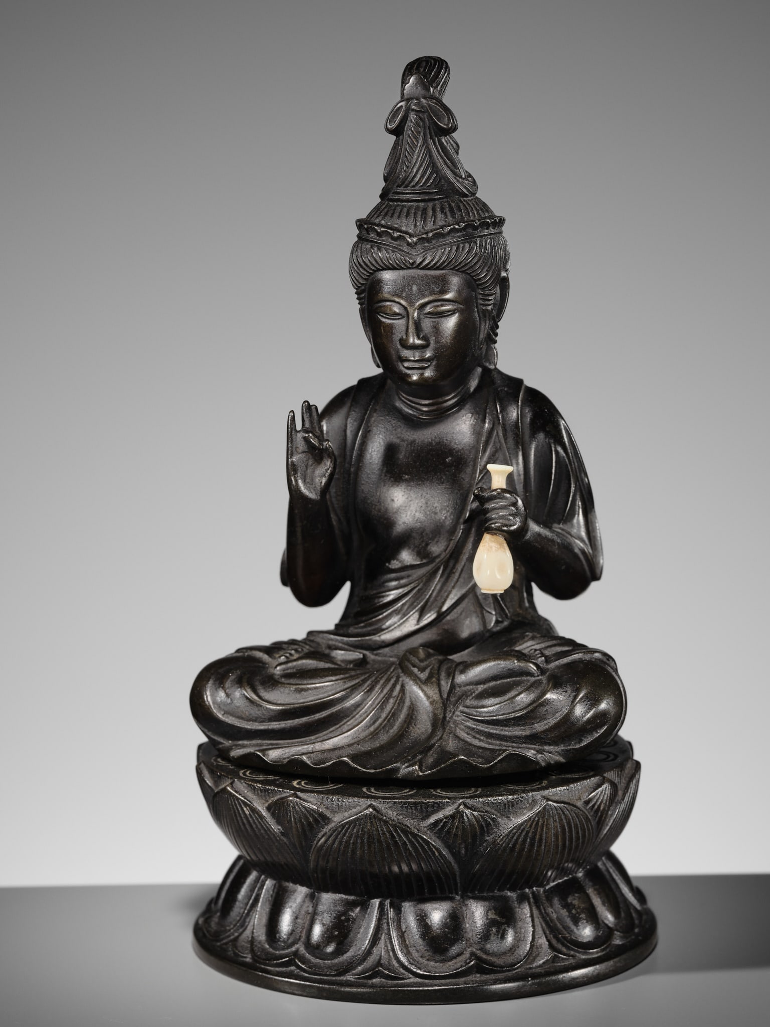 WATANABE OMI: A VERY FINE BRONZE FIGURE OF KANNON, 17TH CENTURY: WATANABE OMI: A VERY FINE BRONZE FIGURE OF KANNON, 17TH CENTURY By Watanabe Omi (1646-1704), signed Doi Hokkyo saku Japan, late 17th century, Edo period (1615-1868) Cast in two parts, the figure depic
