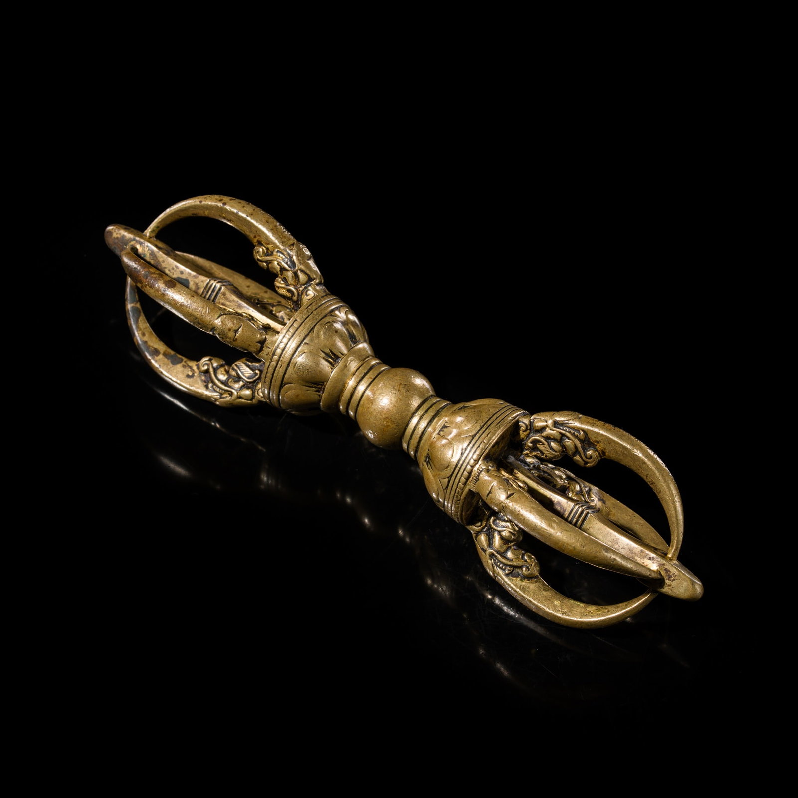 A LARGE BRONZE FOUR-PRONGED VAJRA, DORJE, TIBET, CIRCA 16TH CENTURY: A LARGE BRONZE FOUR-PRONGED VAJRA, DORJE, TIBET, CIRCA 16TH CENTURY Boldly cast, with a central compressed globular grip flanked by two undecorated bands, lotus petals, and further beaded bands, suppo