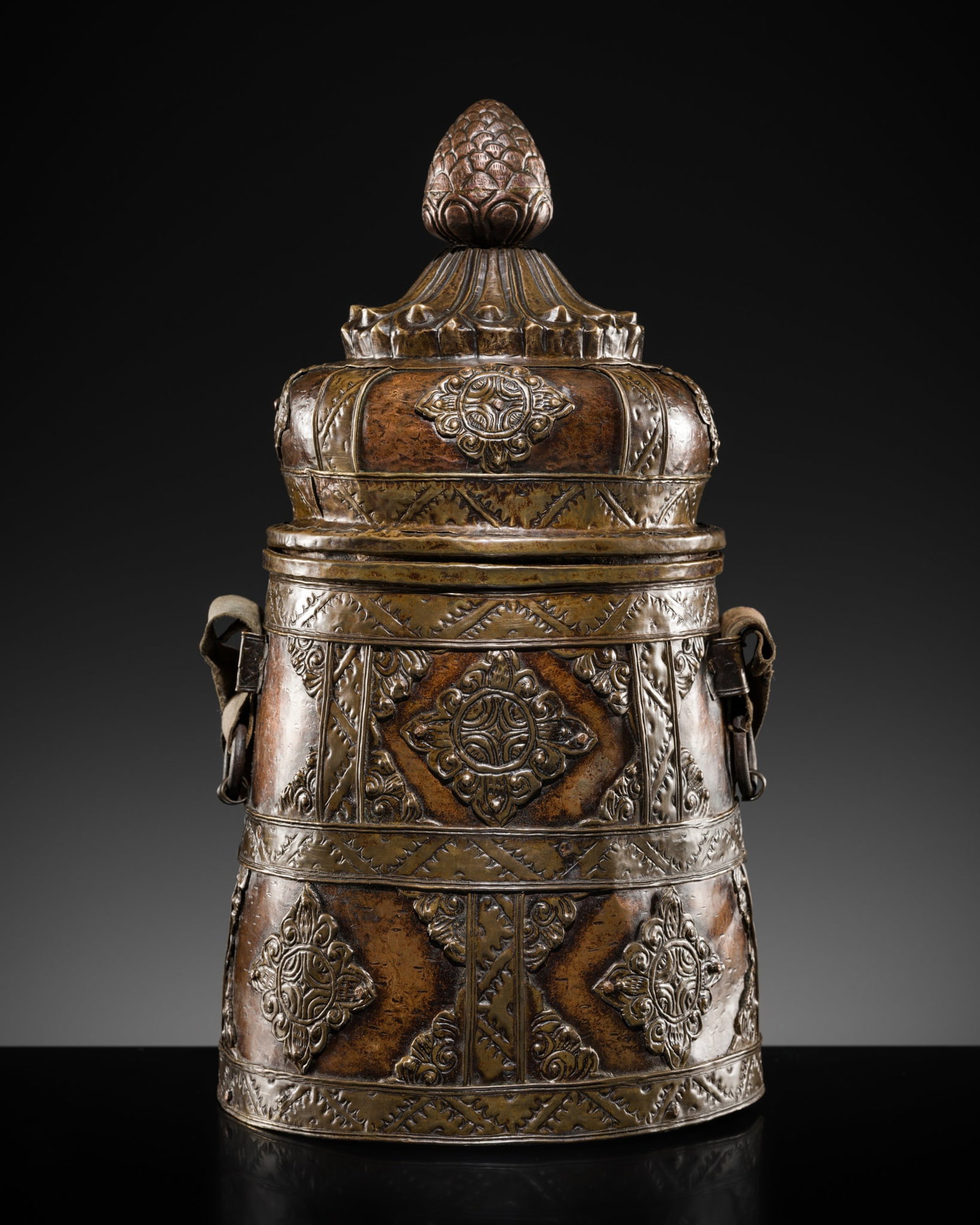 A COPPER REPOUSSÉ MOUNTED BRASS BEER FLASK, CHHAANG, TIBET, 18TH-19TH CENTURY: A COPPER REPOUSSÉ MOUNTED BRASS BEER FLASK, CHHAANG, TIBET, 18TH-19TH CENTURY Of tapered form, the copper body strengthen by vertical and horizontal brass bands forming rectangles, each decorated