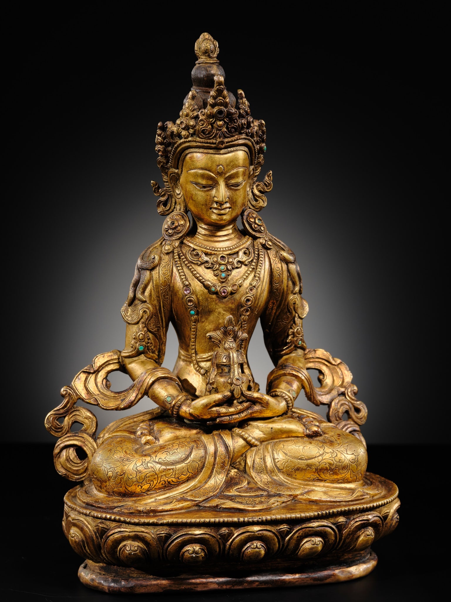 A FINELY INLAID GILT-BRONZE FIGURE OF AMITAYUS, NEPAL, 19TH-FIRST HALF OF 20TH CENTURY: A FINELY INLAID GILT-BRONZE FIGURE OF AMITAYUS, NEPAL, 19TH-FIRST HALF OF 20TH CENTURY Finely cast seated in dhyanasana on a lotus base with beaded edges, the hands lowered in dhyana mudra and support