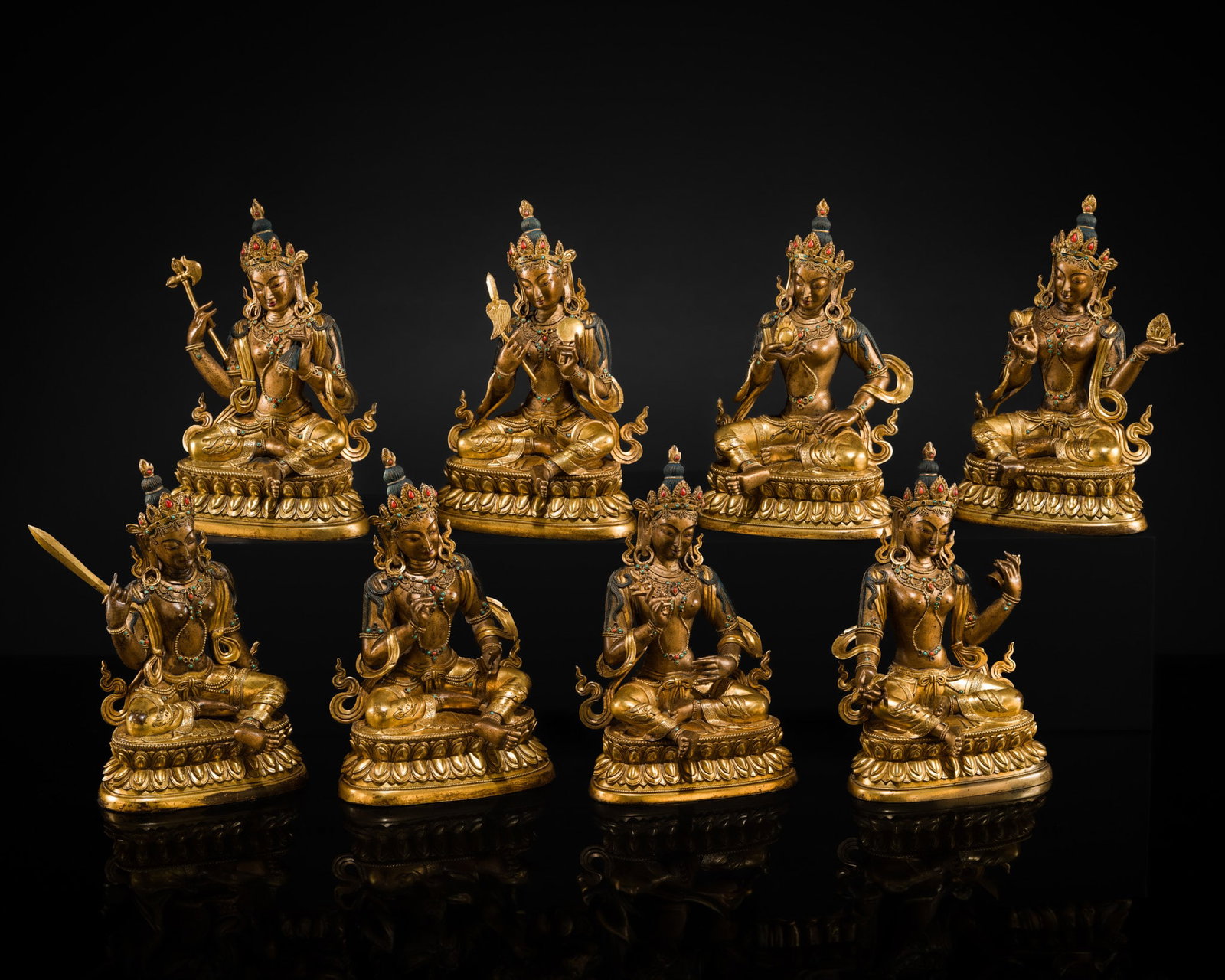 A MAGNIFICENT GROUP OF EIGHT CORAL AND TURQUOISE INLAID GILT COPPER FIGURES OF THE EIGHT GREAT: † A MAGNIFICENT GROUP OF EIGHT CORAL AND TURQUOISE INLAID GILT COPPER FIGURES OF THE EIGHT GREAT BODHISATTVAS, TIBET, 20TH CENTURY Each finely cast, seated in lalitasana atop a beaded double-lot