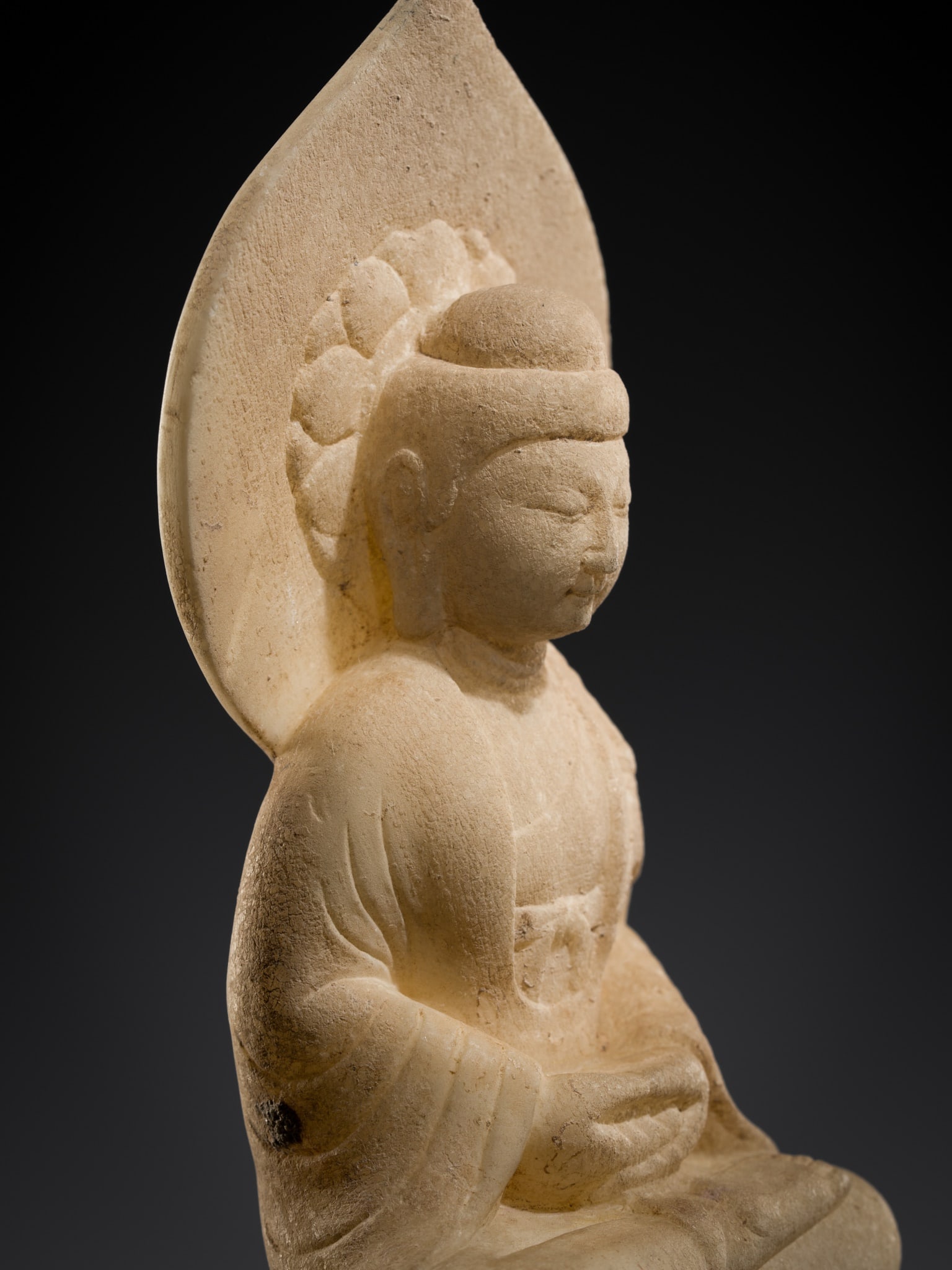 A SMALL WHITE MARBLE STELE OF BUDDHA SHAKYAMUNI, TANG DYNASTY: A SMALL WHITE MARBLE STELE OF BUDDHA SHAKYAMUNI, TANG DYNASTY China, 618-907. Finely carved seated in ardhapadmasana atop a stepped pedestal, the hands lowered above the lap in dhyanamudra, dressed in