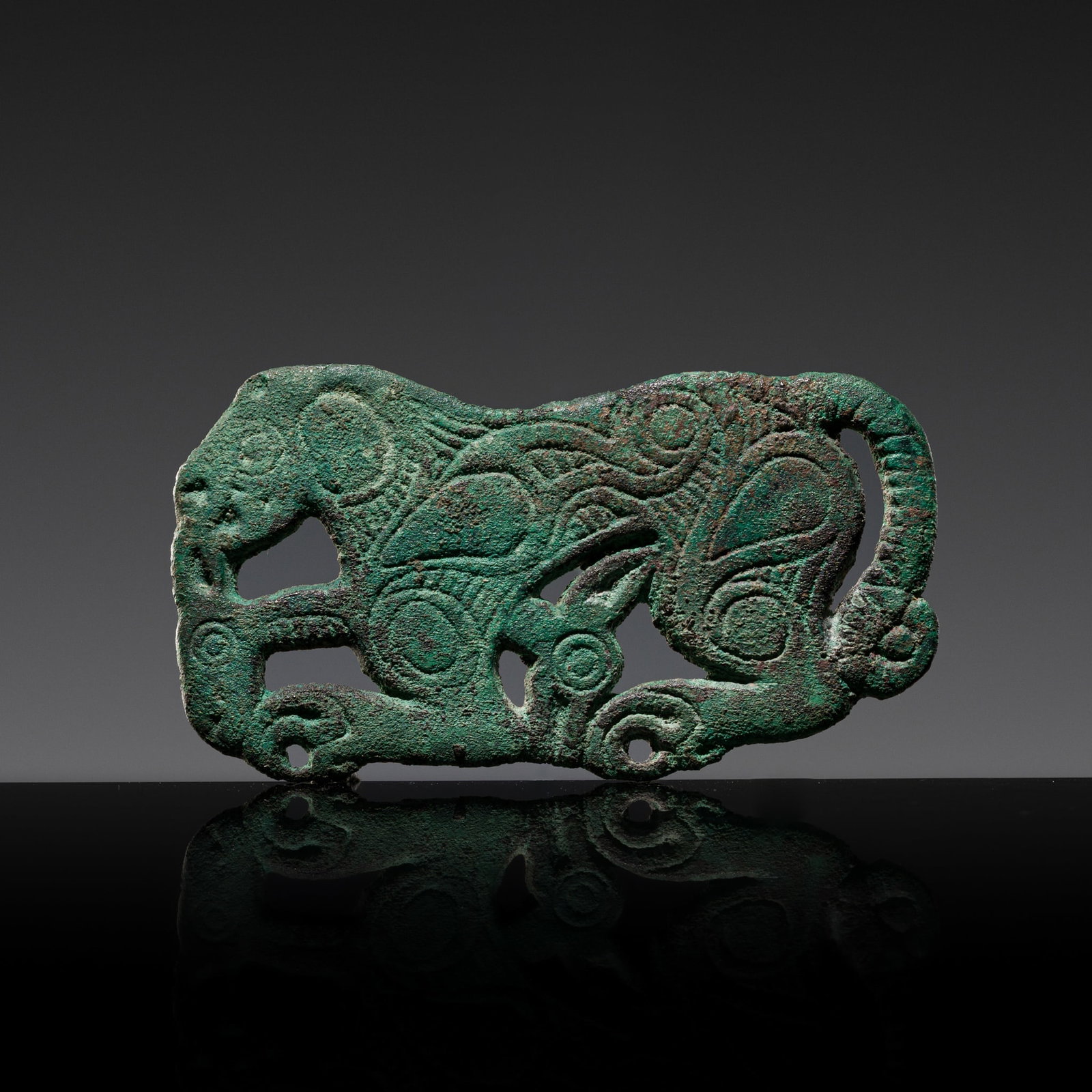 A BRONZE 'TIGER DEVOURING AN IBEX' BELT ORNAMENT, 6TH-2ND CENTURY BC: A BRONZE 'TIGER DEVOURING AN IBEX' BELT ORNAMENT, 6TH-2ND CENTURY BC Northern China, Inner Mongolia, Ordos. Of flattened form, finely modeled as a tiger devouring the head of an ibex, a second head be