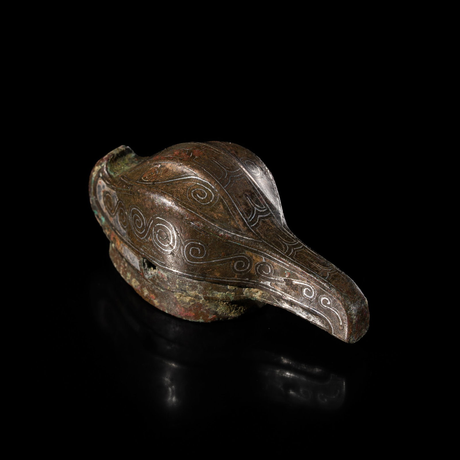 A SILVER INLAID BRONZE 'BIRD HEAD' SHAFT FINIAL, WARRING STATES PERIOD: A SILVER INLAID BRONZE 'BIRD HEAD' SHAFT FINIAL, WARRING STATES PERIOD China, 475-221 BC. Well cast in the form of a bird head terminating in a long beak to one end and a curled feather to the other e