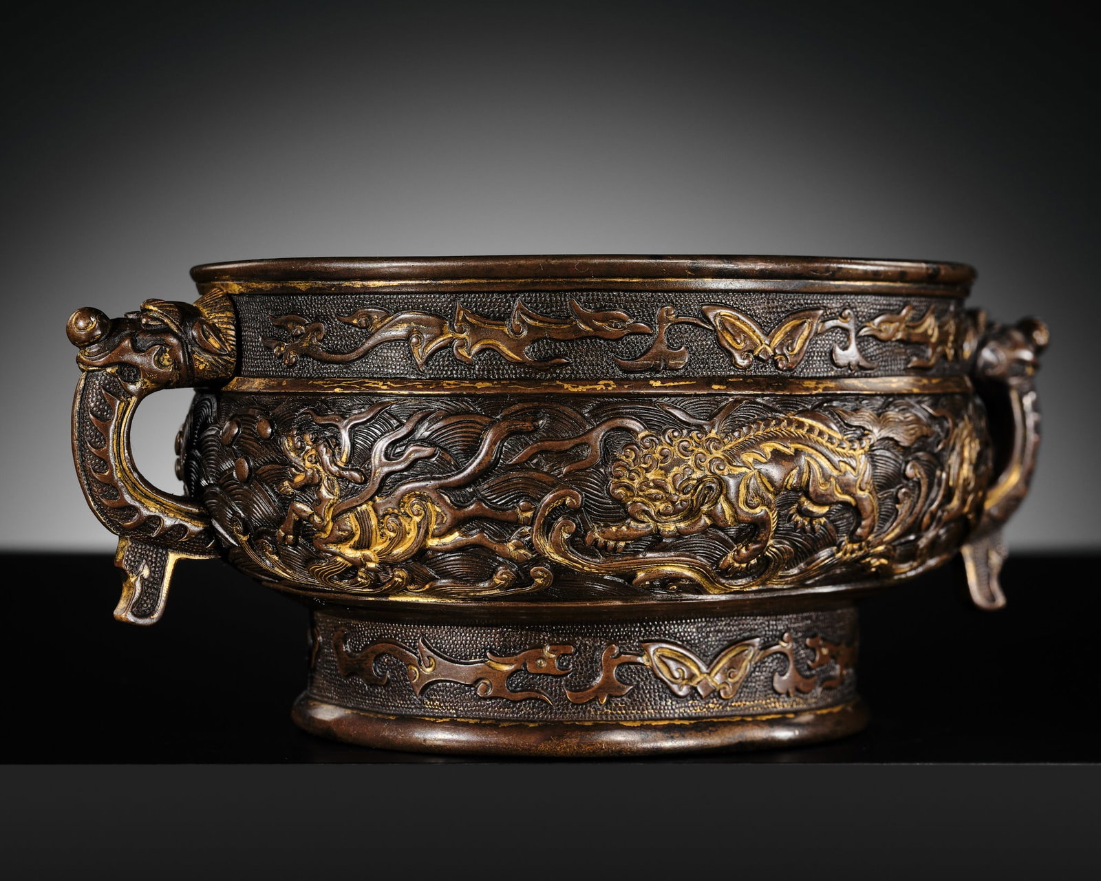 A HU WENMING PARCEL-GILT BRONZE 'BUDDHIST LIONS' CENSER, GUI, MING DYNASTY: A HU WENMING PARCEL-GILT BRONZE 'BUDDHIST LIONS' CENSER, GUI, MING DYNASTY China, late 16th-early 17th century. Finely cast, of bombé form with a compressed body supported on a tall, slightly fla