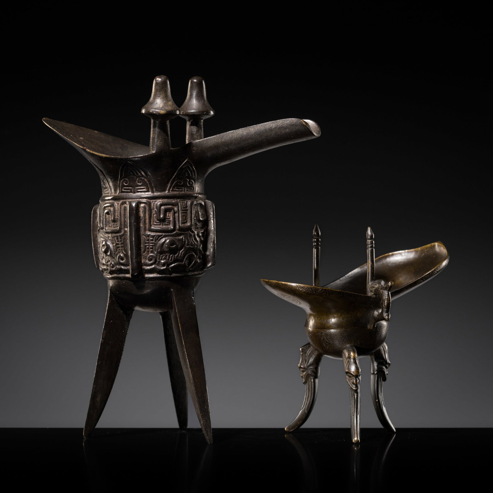A GROUP OF TWO INSCRIBED ARCHAISTIC BRONZE RITUAL VESSELS, JUE, QING DYNASTY: A GROUP OF TWO INSCRIBED ARCHAISTIC BRONZE RITUAL VESSELS, JUE, QING DYNASTY Expert's note: The present pair of archaistic bronze jue reflects the enduring role of ancient ritual forms within the cere