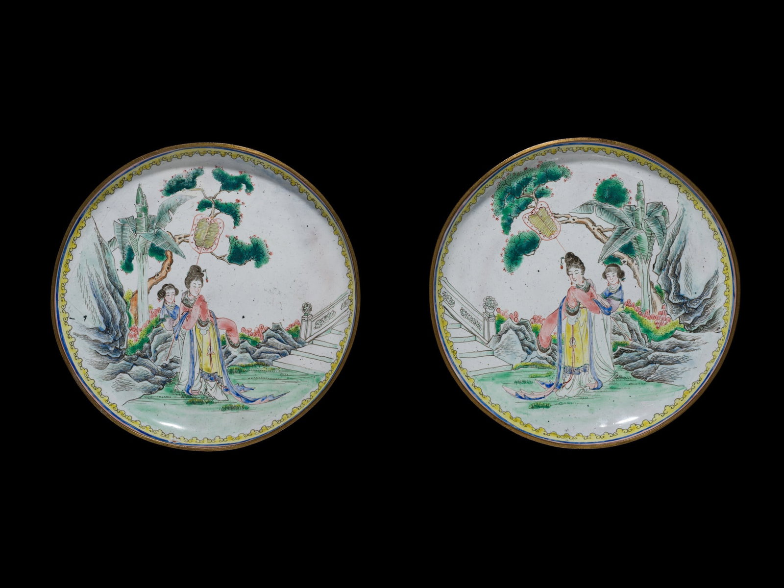 A PAIR OF PAINTED ENAMEL 'LADIES IN PALACE GARDEN' DISHES, LATE QING DYNASTY-REPUBLIC PERIOD: A PAIR OF PAINTED ENAMEL 'LADIES IN PALACE GARDEN' DISHES, LATE QING DYNASTY-REPUBLIC PERIOD China, 1800-1949. The shallow dishes are finely enameled, each decorated with a court lady attended by a fe