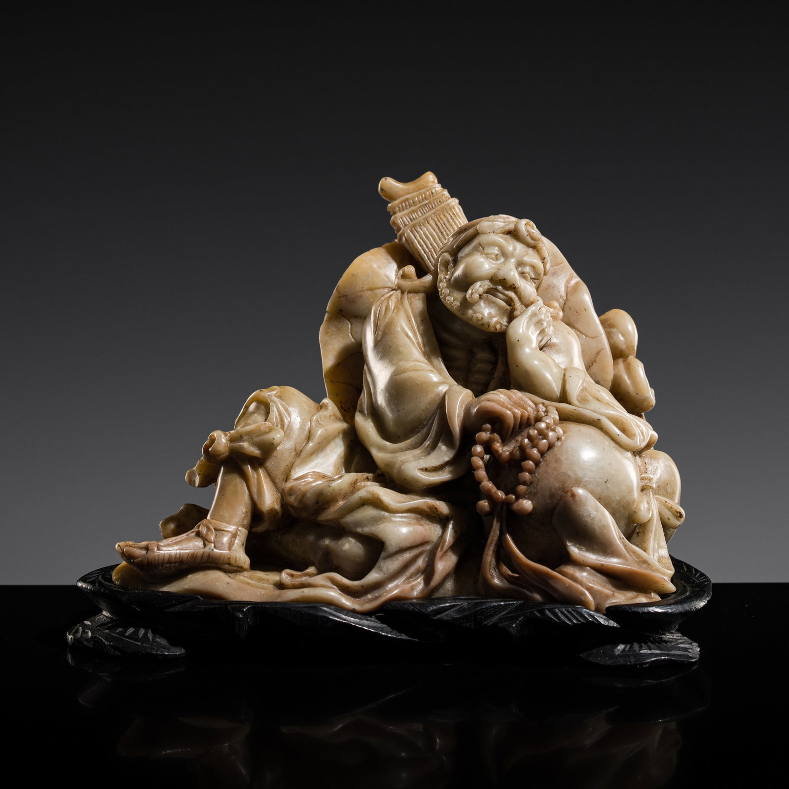 A SOAPSTONE FIGURE OF A LUOHAN, LATE QING DYNASTY (1 of 15)