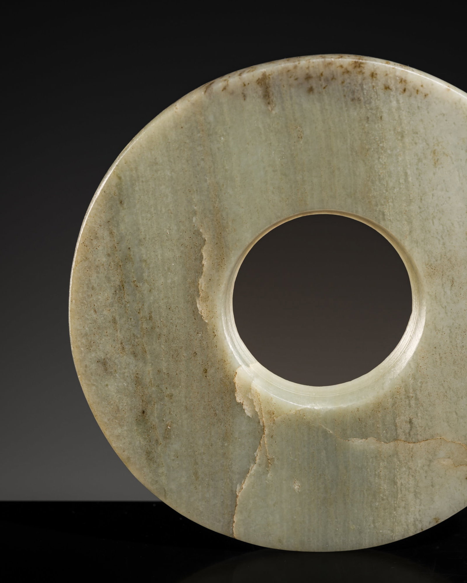 A PALE CELADON JADE DISK, BI, LATE NEOLITHIC-WESTERN ZHOU PERIOD (1 of 14)