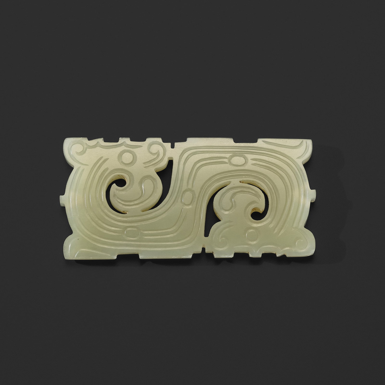 A PALE CELADON JADE 'DRAGON' PLAQUE, LATE WESTERN ZHOU DYNASTY (1 of 14)