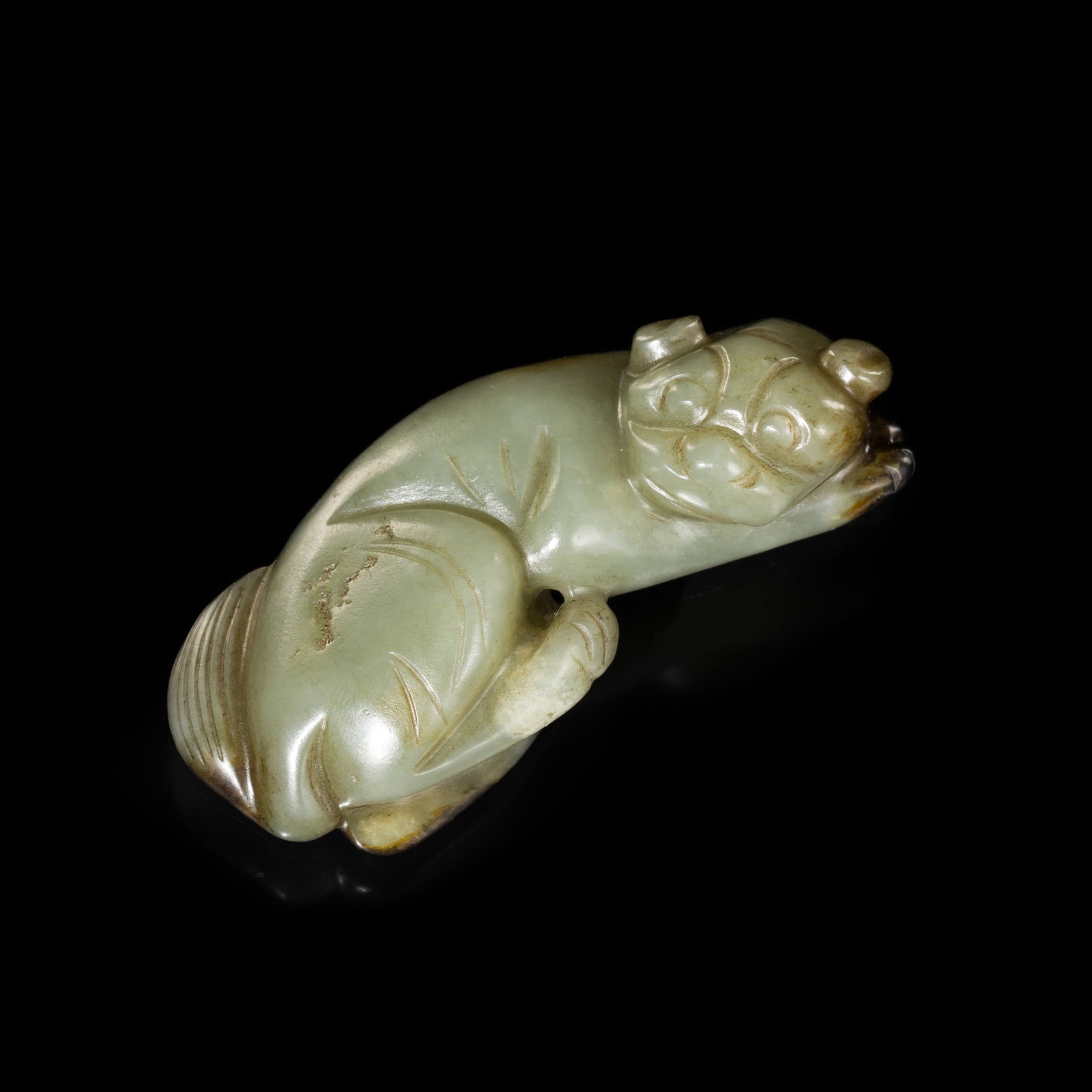 A CELADON JADE FIGURE OF A RECUMBENT DOG, 17TH-18TH CENTURY (1 of 11)