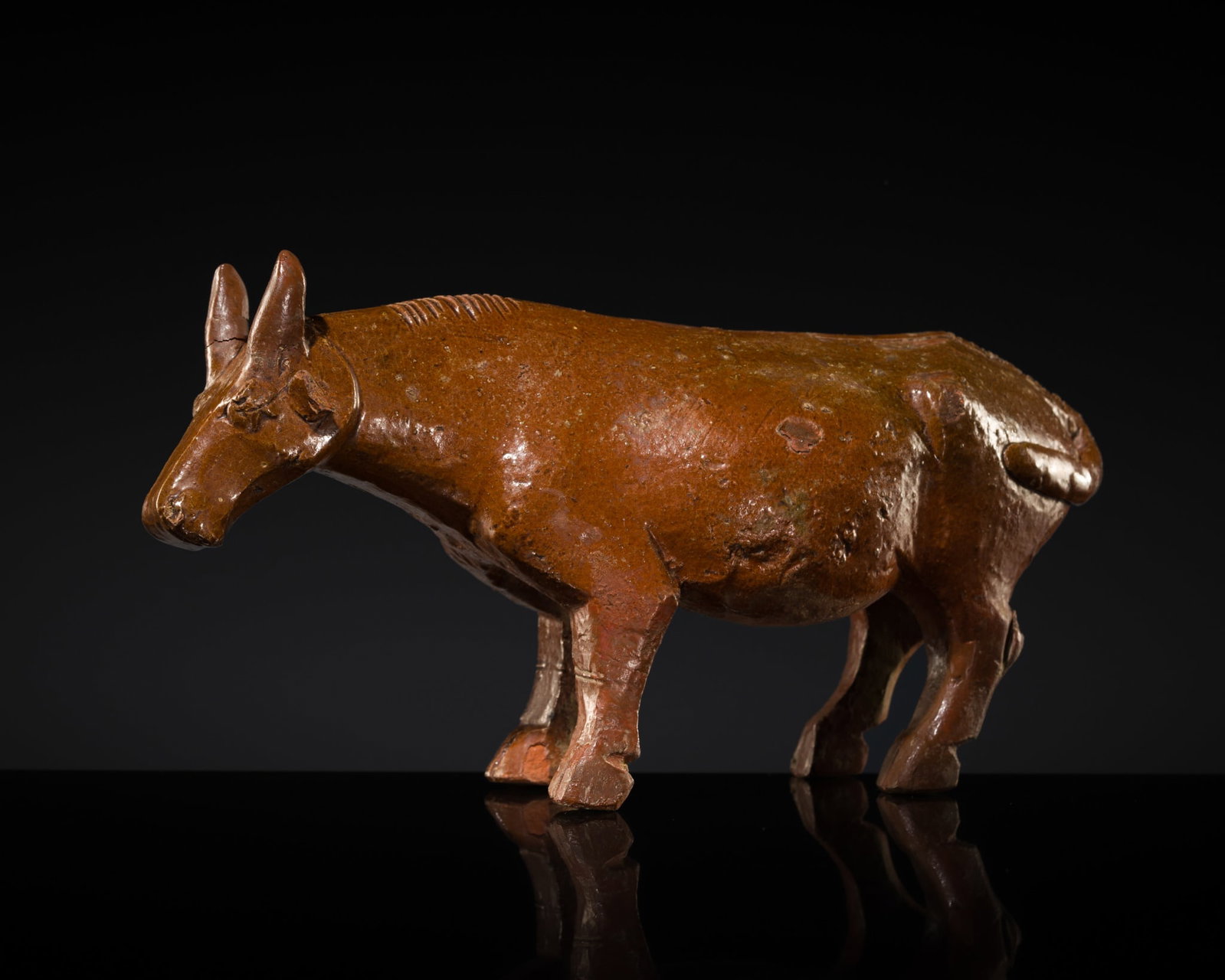 AN AMBER-GLAZED RED POTTERY FIGURE OF AN OX, HAN DYNASTY (1 of 14)