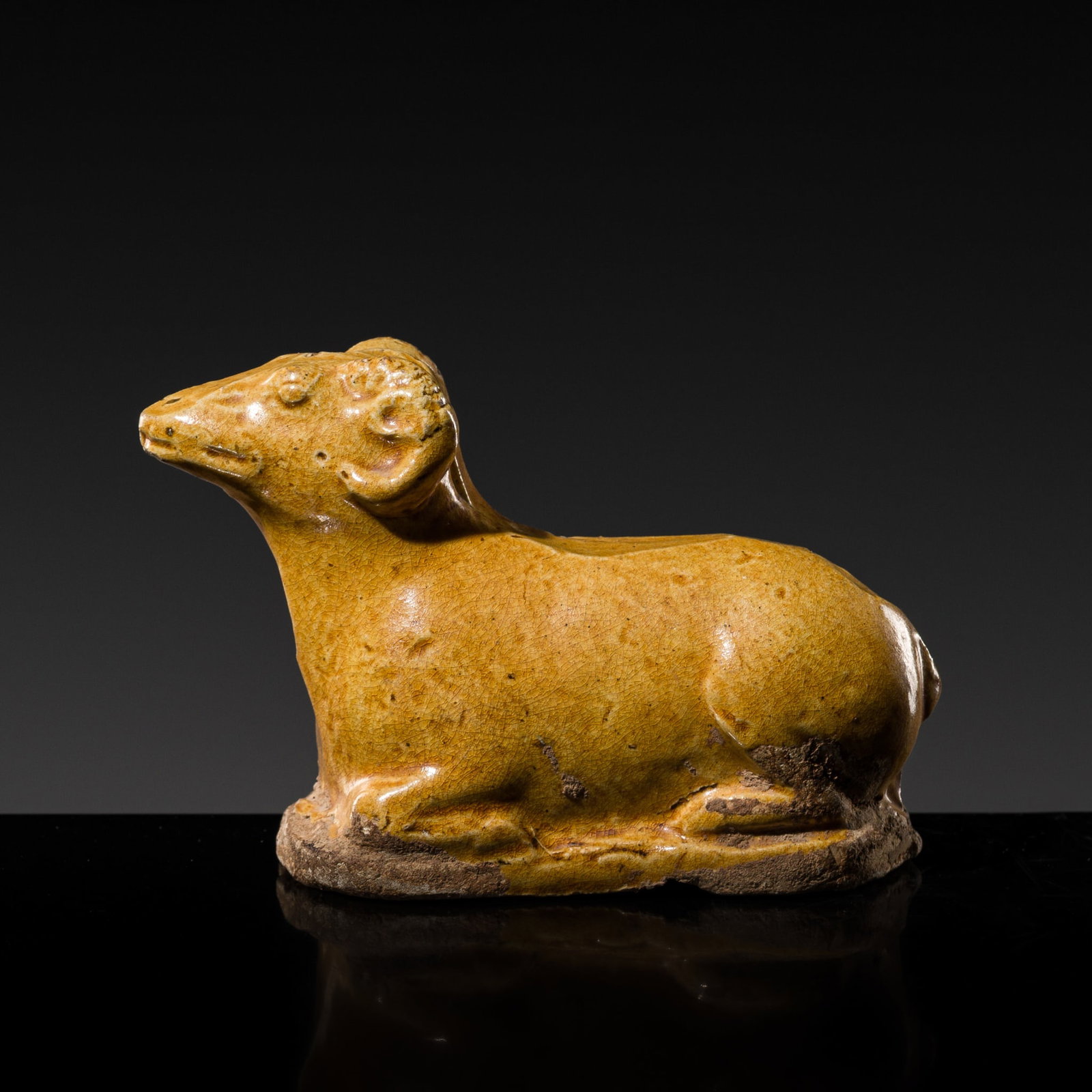 A RARE MINIATURE AMBER-GLAZED EARTHENWARE FIGURE OF A RAM, TANG DYNASTY: A RARE MINIATURE AMBER-GLAZED EARTHENWARE FIGURE OF A RAM, TANG DYNASTY Published & Exhibited: Ben Janssens Oriental Art, TEFAF London, 2018, p. 18-19. China, 618-906. Naturalistically modeled, sh
