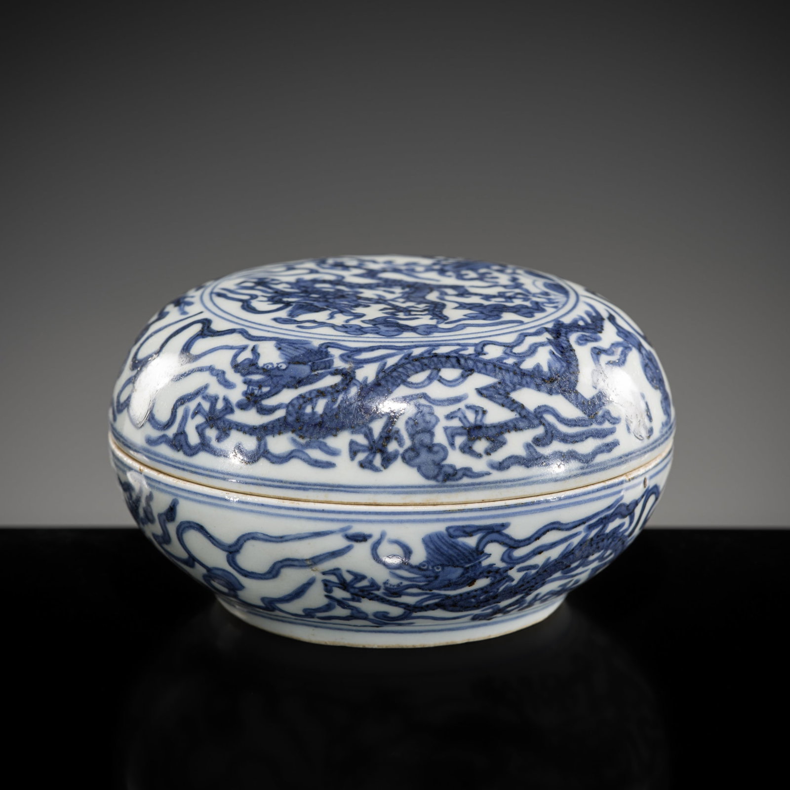 A BLUE AND WHITE 'DRAGON' CIRCULAR BOX AND COVER, WANLI MARK AND PERIOD: A BLUE AND WHITE 'DRAGON' CIRCULAR BOX AND COVER, WANLI MARK AND PERIOD Expert's note: It is recorded in the Grand Gazetteer of Jiangxi Province: Volume VII that “blue and white 'dragon' boxes&#