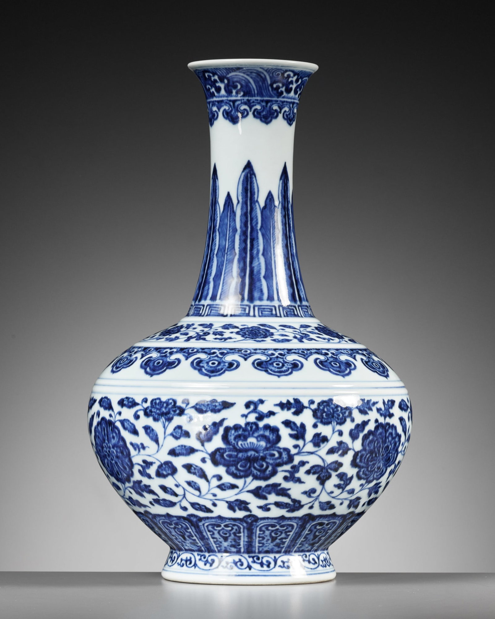 A BLUE AND WHITE 'MING-STYLE' BOTTLE VASE, QIANLONG MARK AND PERIOD: A BLUE AND WHITE 'MING-STYLE' BOTTLE VASE, QIANLONG MARK AND PERIOD China, 1736-1795. Well potted, the compressed globular body rising from a short splayed foot, sweeping up to a tall waisted neck fla
