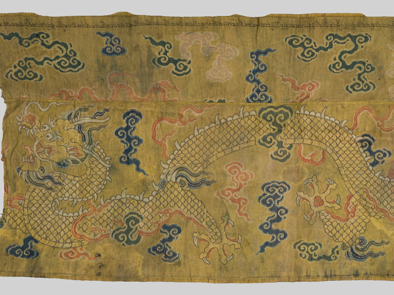 AN INSCRIBED YELLOW-GROUND EMBROIDERED SILK 'DRAGON' PANEL, MING DYNASTY, 16TH-17TH CENTURY: AN INSCRIBED YELLOW-GROUND EMBROIDERED SILK 'DRAGON' PANEL, MING DYNASTY, 16TH-17TH CENTURY Expert's note: The distinctive yellow ground, known as xiangse (incense color), together with the depiction 