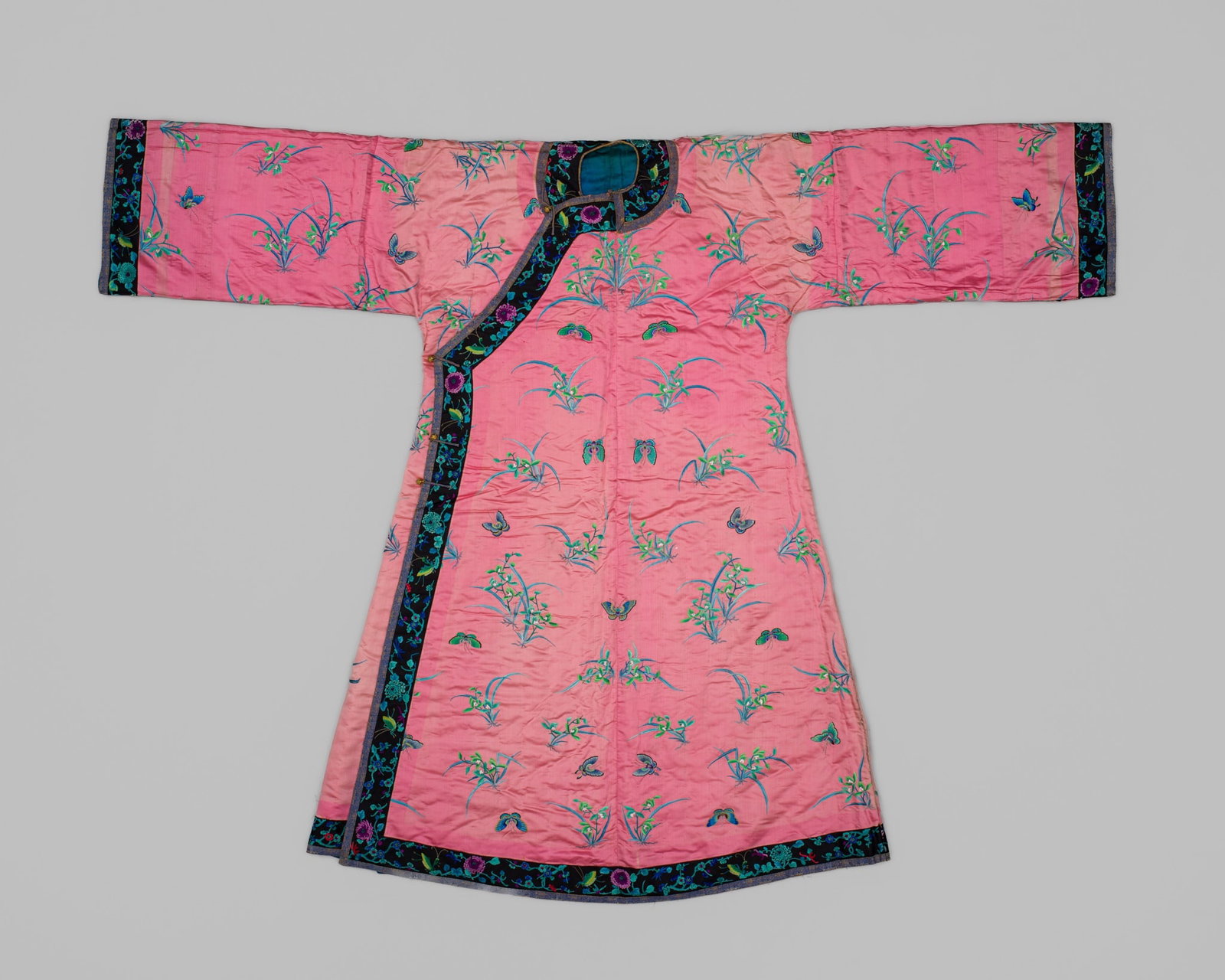 A FINE EMBROIDERED PINK SATIN MANCHU WOMAN'S INFORMAL ROBE, CHANGYI, LATE QING DYNASTY: A FINE EMBROIDERED PINK SATIN MANCHU WOMAN'S INFORMAL ROBE, CHANGYI, LATE QING DYNASTY China, 19th-early 20th century. The vibrant pink satin finely embroidered in polychrome silk using the Beijing st