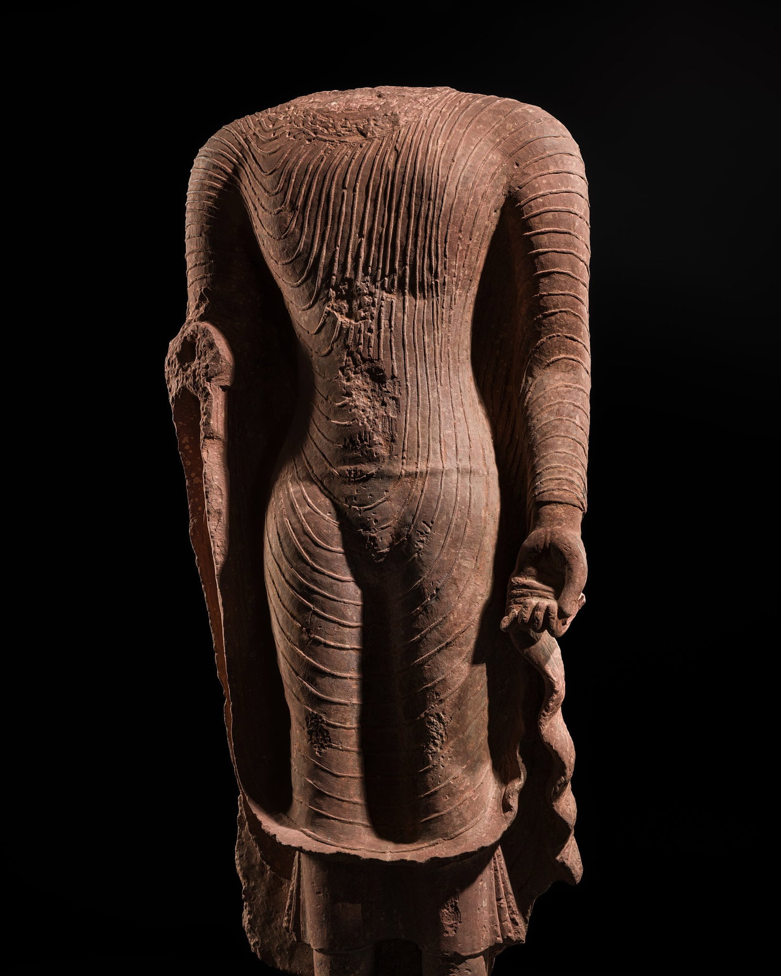 AN ICONIC RED SANDSTONE TORSO OF THE BUDDHA, GUPTA PERIOD, MATHURA, 3RD-5TH CENTURY: † AN ICONIC RED SANDSTONE TORSO OF THE BUDDHA, GUPTA PERIOD, MATHURA, 3RD-5TH CENTURY Expert authentication: Dr. Chang Qing has authenticated this lot, identifying its iconographic and stylistic
