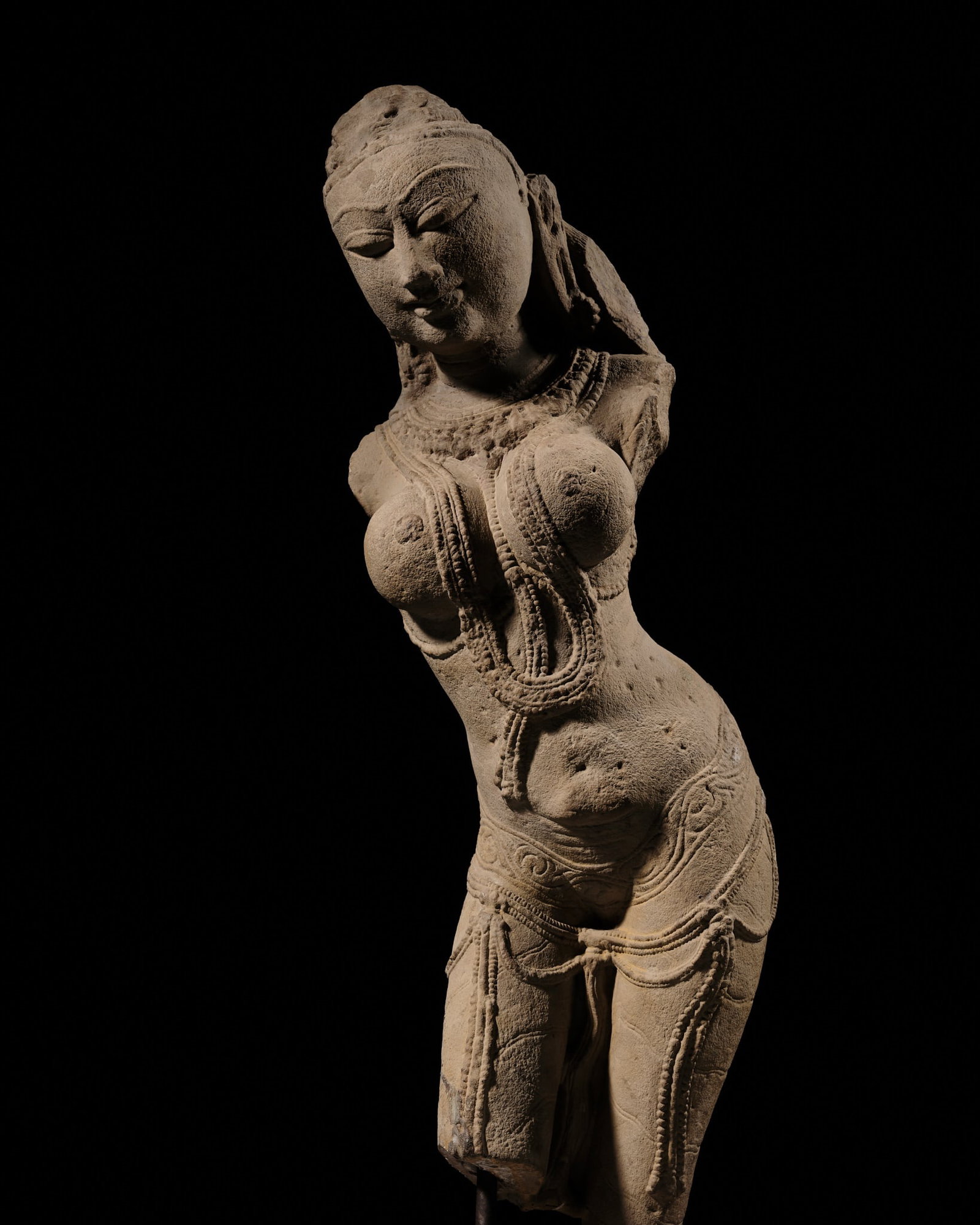 A SANDSTONE FIGURE OF A CELESTIAL BEAUTY, SURASUNDARI, CENTRAL INDIA, CHANDELA DYNASTY, 10TH-11TH: A SANDSTONE FIGURE OF A CELESTIAL BEAUTY, SURASUNDARI, CENTRAL INDIA, CHANDELA DYNASTY, 10TH-11TH CENTURY Superbly carved, leaning to her right, the effortless beauty of this semi-divine female is hig