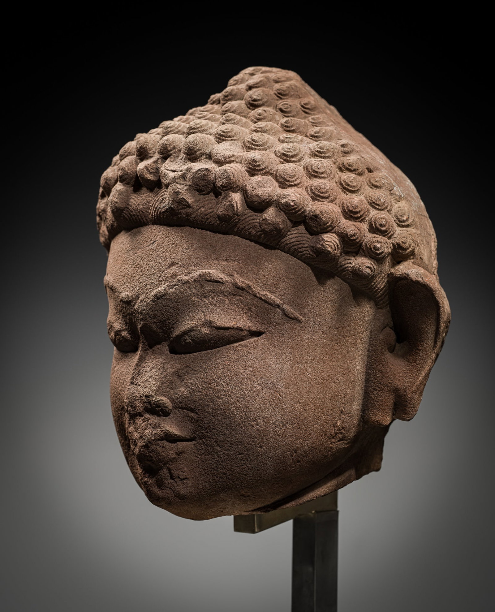 A LARGE RED SANDSTONE HEAD OF A JAIN TIRTHANKARA, INDIA, 11TH-12TH CENTURY (1 of 10)