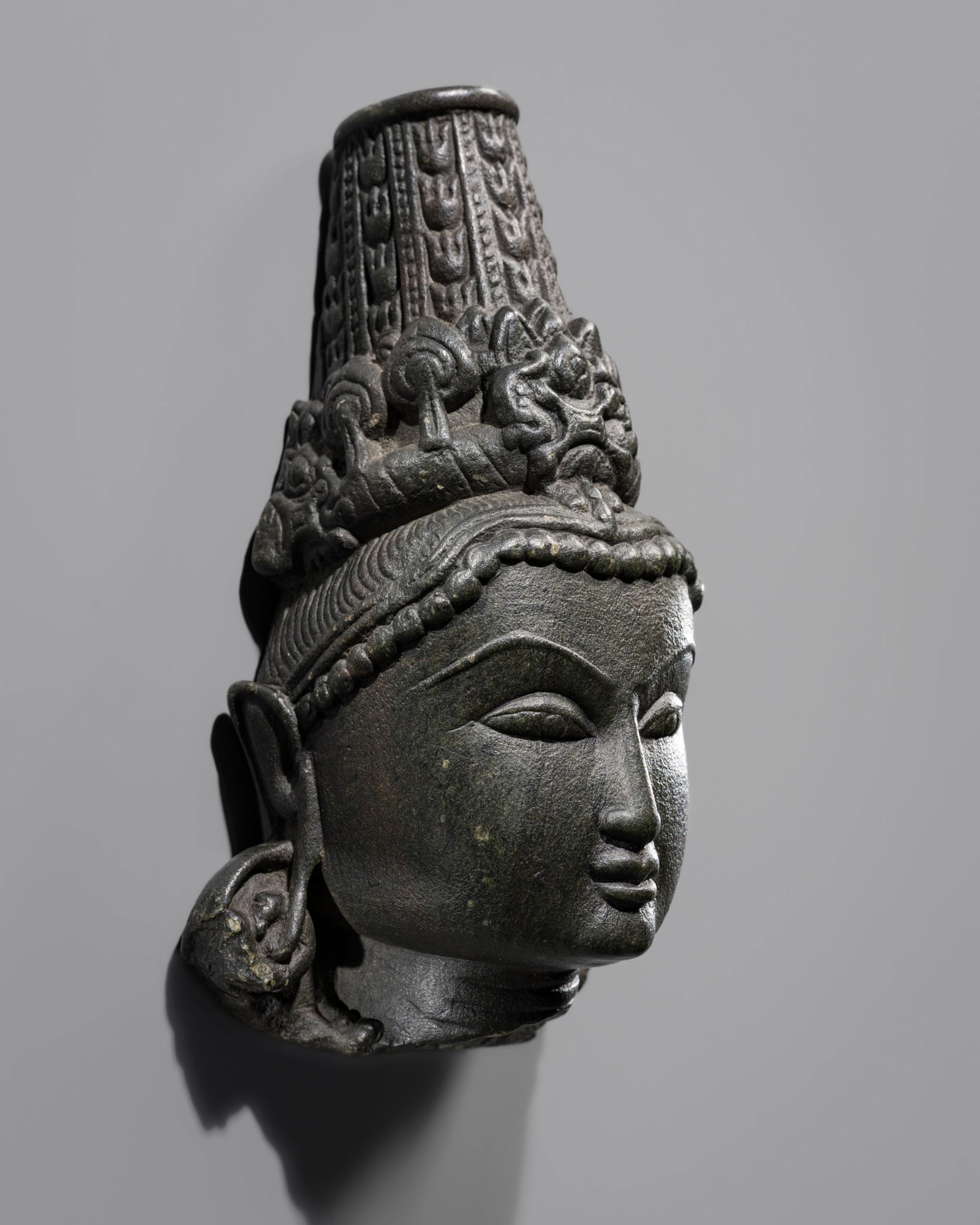 A BLACK STONE HEAD OF INDRA, SOLANKI DYNASTY, 11TH-12TH CENTURY (1 of 12)