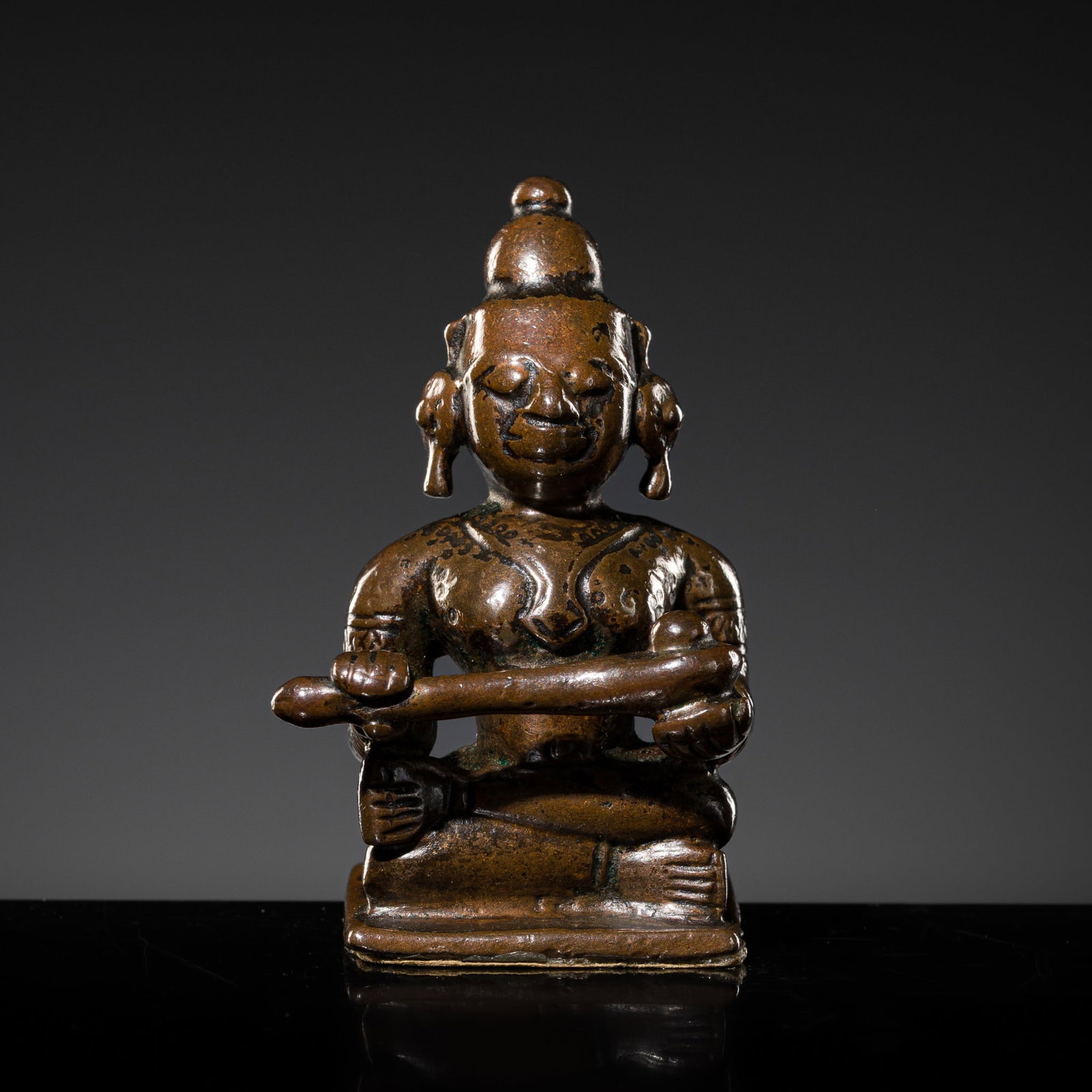 A SMALL COPPER-ALLOY FIGURE OF ANNAPURNA, DECCAN, 17TH-18TH CENTURY: A SMALL COPPER-ALLOY FIGURE OF ANNAPURNA, DECCAN, 17TH-18TH CENTURY India. Seated in padmasana on a lotus base raised on a flat plinth, the goddess of food and nourishment portrayed holding a ladle wi