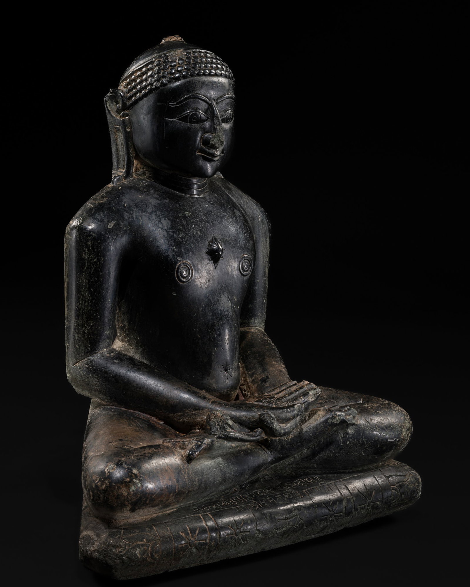 A JAIN BLACK STONE FIGURE OF A TIRTHANKARA, WESTERN INDIA, CIRCA 17TH-18TH CENTURY OR EARLIER (1 of 13)